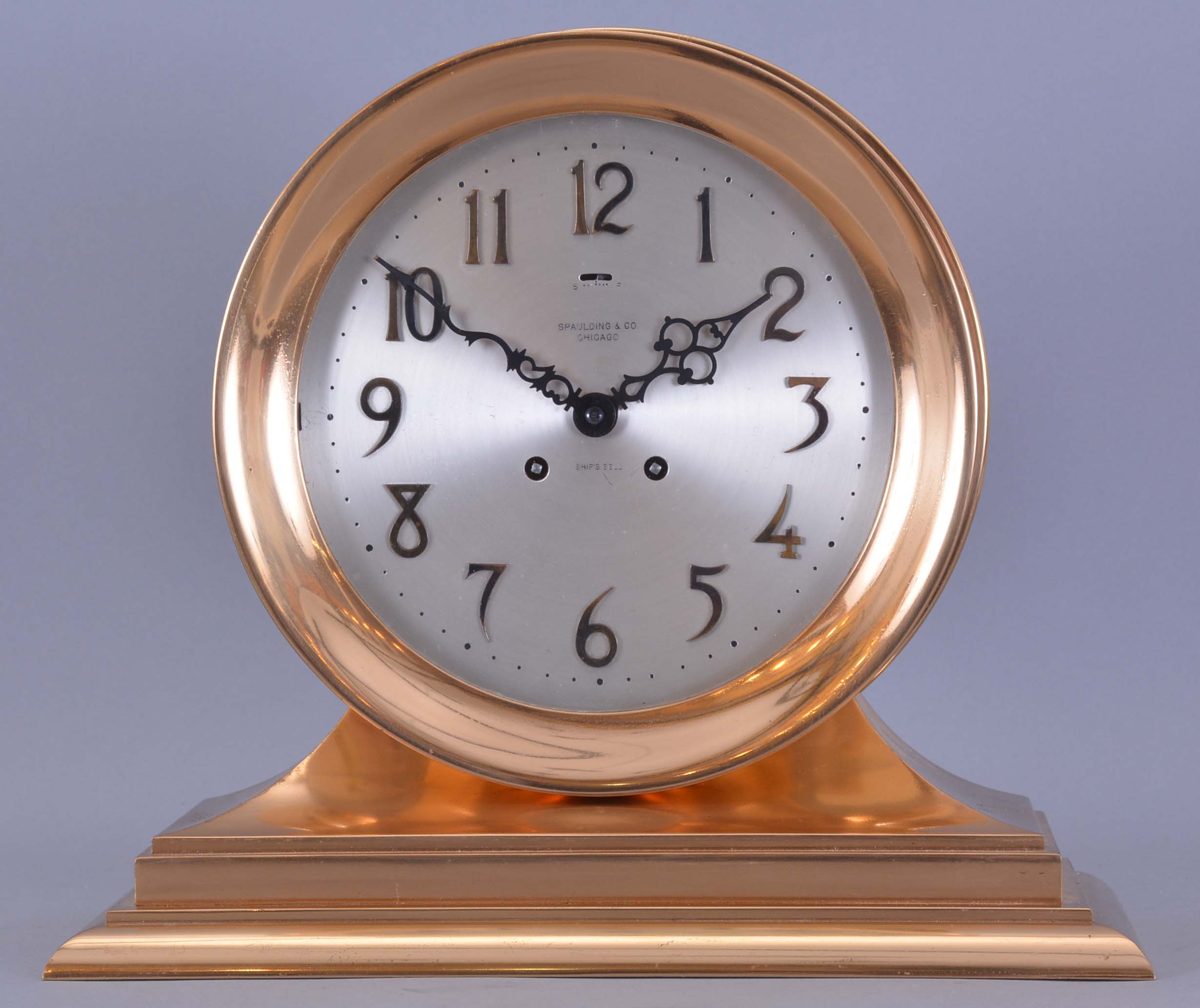 Chelsea Clock Co., Boston, Mass., retailed by Spaulding &amp; Co., Chicago, "Commander" on metal base with 8 1/2" special dial, 8 day, spring driven, time and ship's bell striking movement in a polished brass case mantel clock — Antique Clocks Price Guide