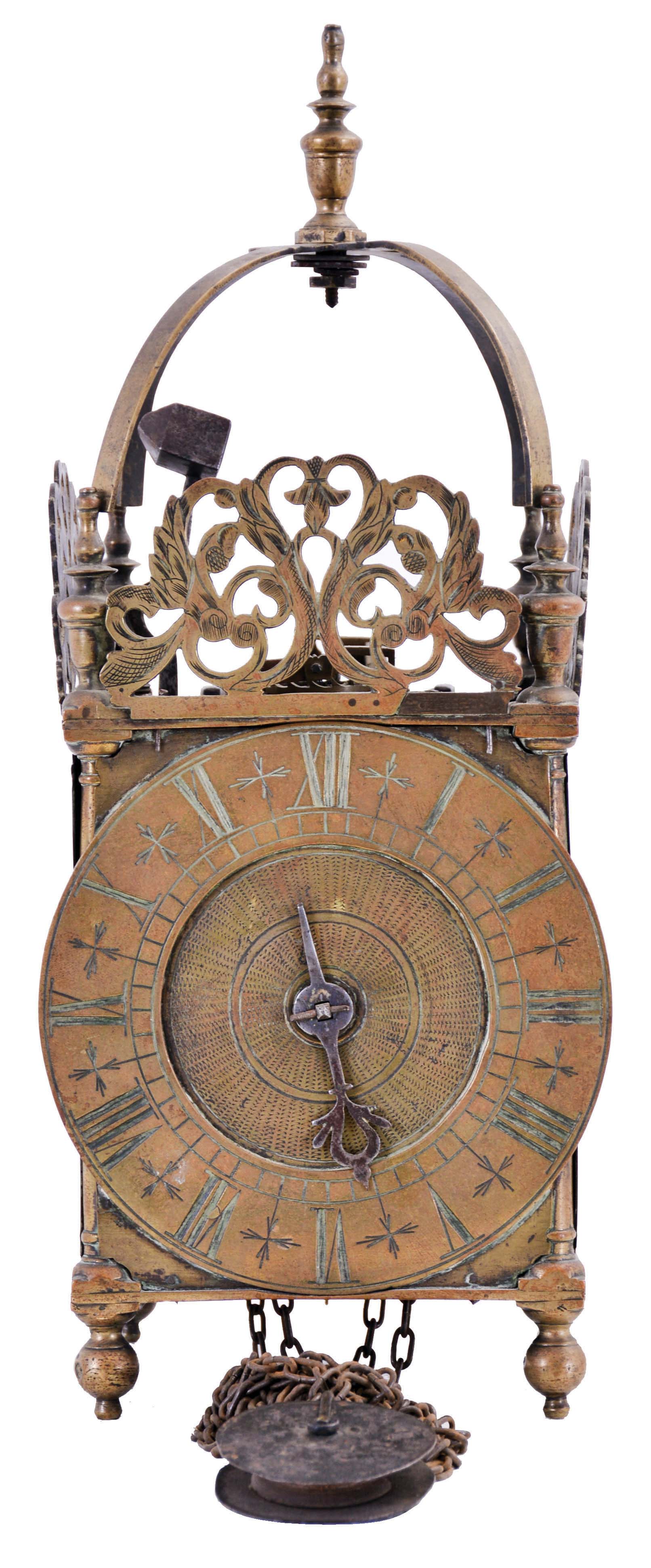 England, unsigned lantern clock, the brass case with turned columns, finials, and feet, top with pierced frets, the front fret with engraving, Roman numeral brass dial, pierced steel hand, 30 hour, weight driven time and strike bob pendulum movement with crown wheel escapement. — Antique Clocks Price Guide