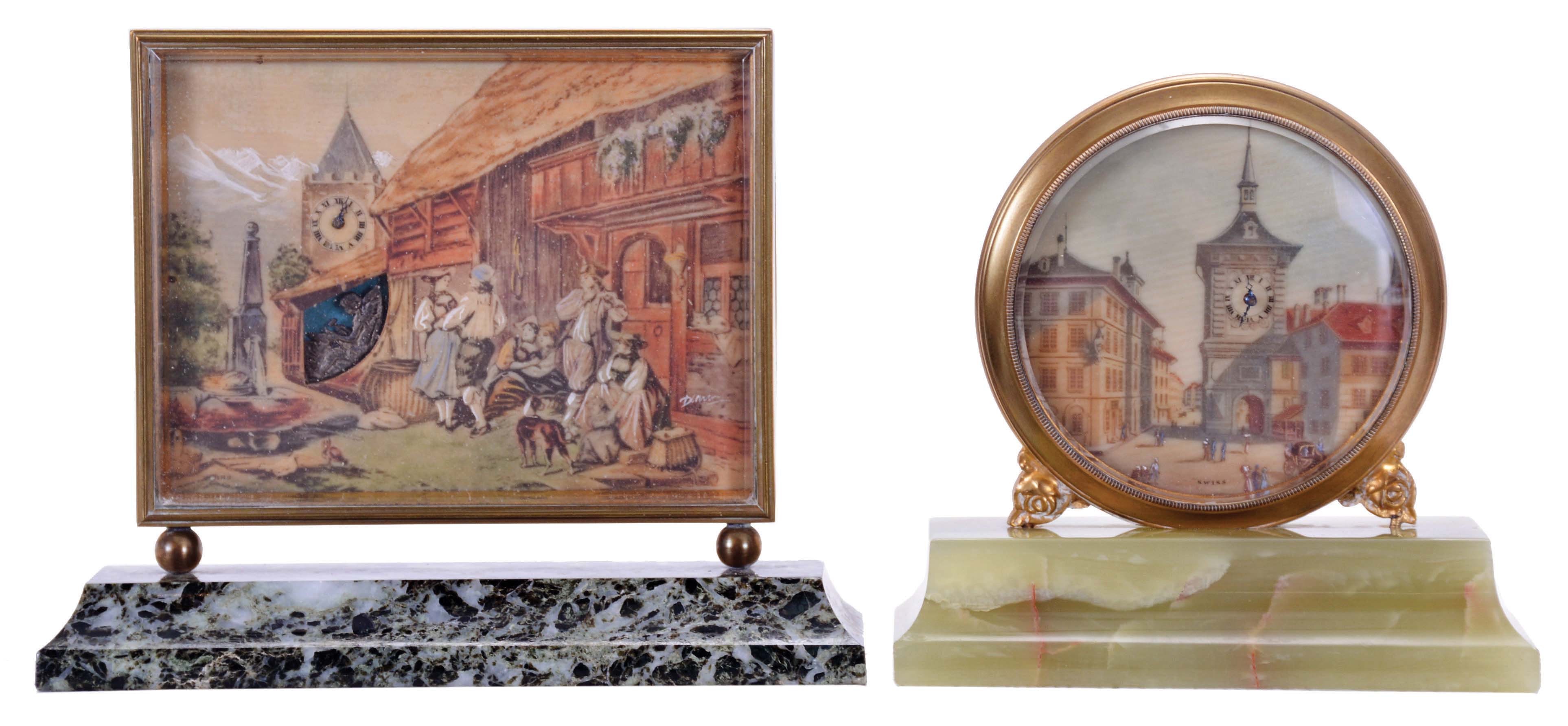Didisheim, Goldschmidt, Fils &amp; Co., Switzerland- 2 (Two) 30 hour desk timepieces: (1) the first marked "Idylle au Village" and features a European scene, and with an automated Cupid forging arrows below the clock tower, mounted to a green, variegated marble base, (2) the other with European streetscape, featuring buildings and a clock tower, and mounted to a green onyx base, dimensions of first clock listed — Antique Clocks Price Guide