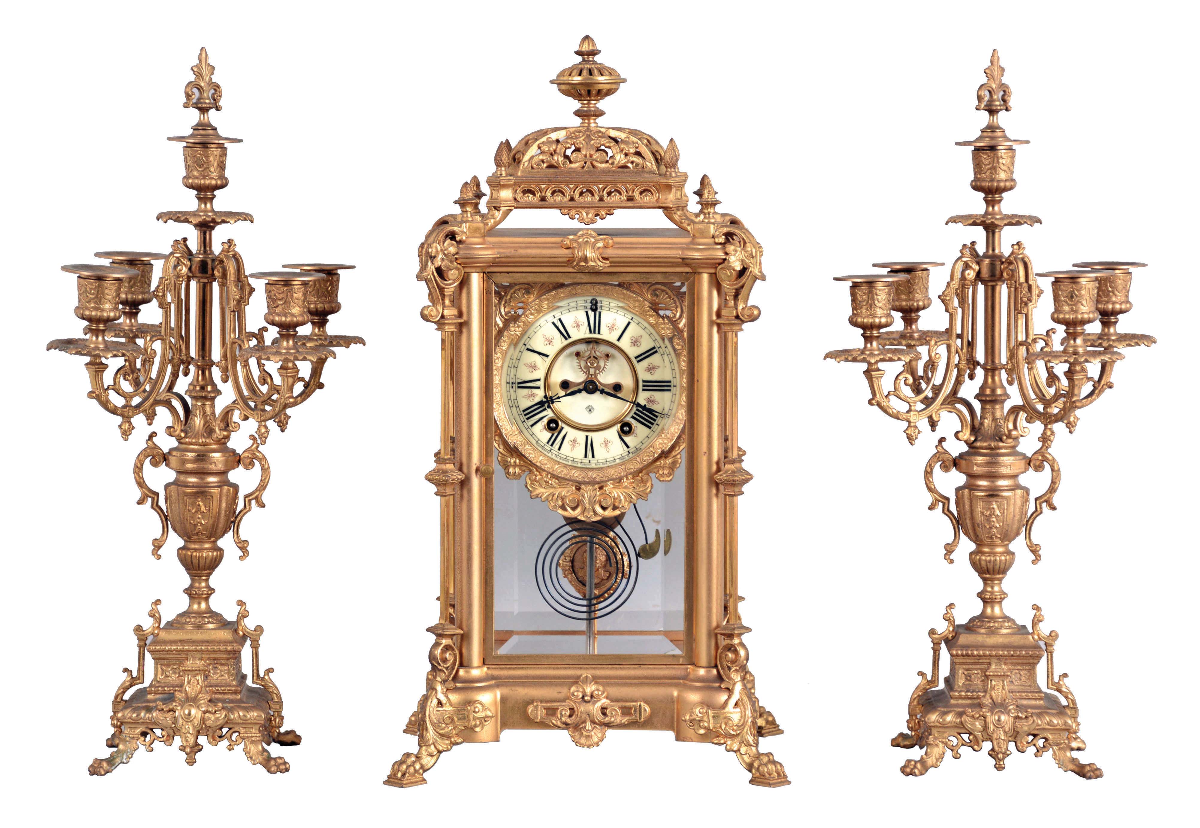 Ansonia Clock Co., New York, NY, "Excelsior" Crystal Regulator with two matching candelabra (No. 1110) with a spring driven, 8 day time and half hour strike movement (rack &amp; snail strike) in a gilt finished brass case. — Antique Clocks Price Guide
