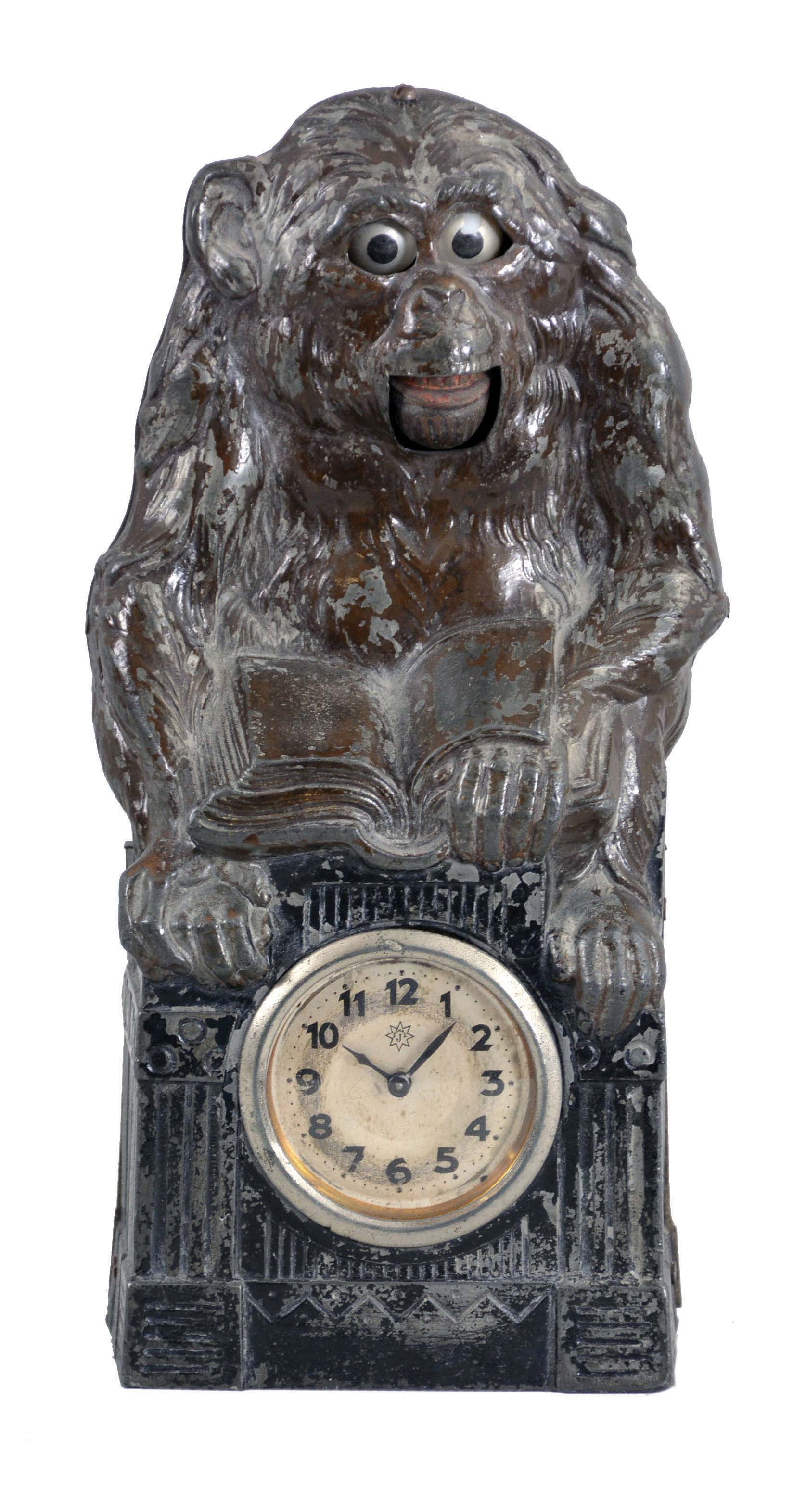 Junghans, Germany, "Monkey Business" novelty clock, 30 hour, time only spring driven movement in a cast metal case in the form of a monkey holding a book. A line runs up from the movement to the lower jaw and eyes, which are designed to move up and down slowly as the jaw opens and closes, c1920. — Antique Clocks Price Guide