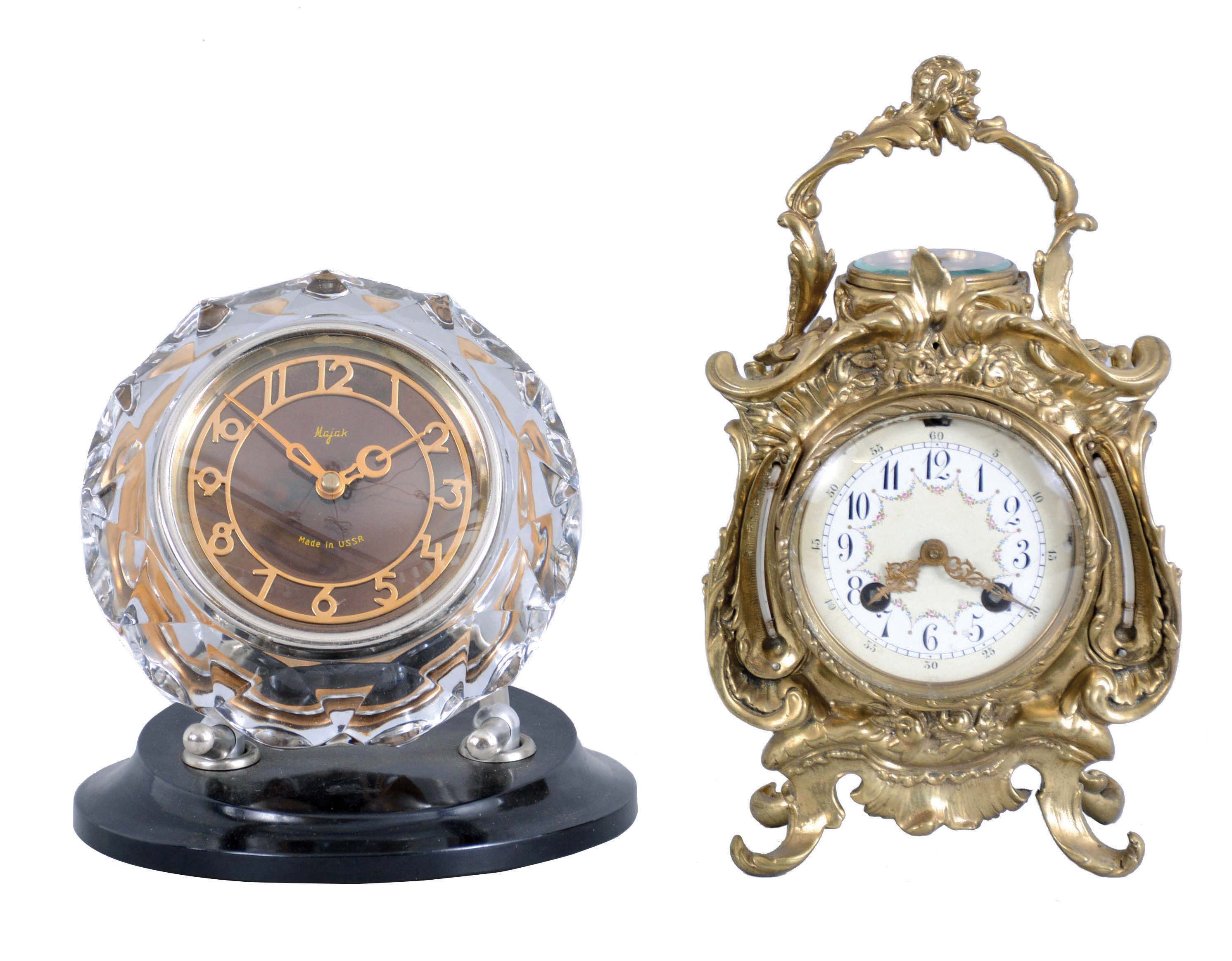 Clocks- 2 (Two) Desk Clocks: (1) France, desk compendium with aneroid barometer and two thermometers, 8 day, time and strike balance wheel movement in a Rococo revival brass case holding a polychrome enamel dial; (2) Majak, USSR, desk clock with balance wheel movement in a Mid-century Modern cut and polished crystal case held by two curved supports mounted to a black plastic base. — Antique Clocks Price Guide