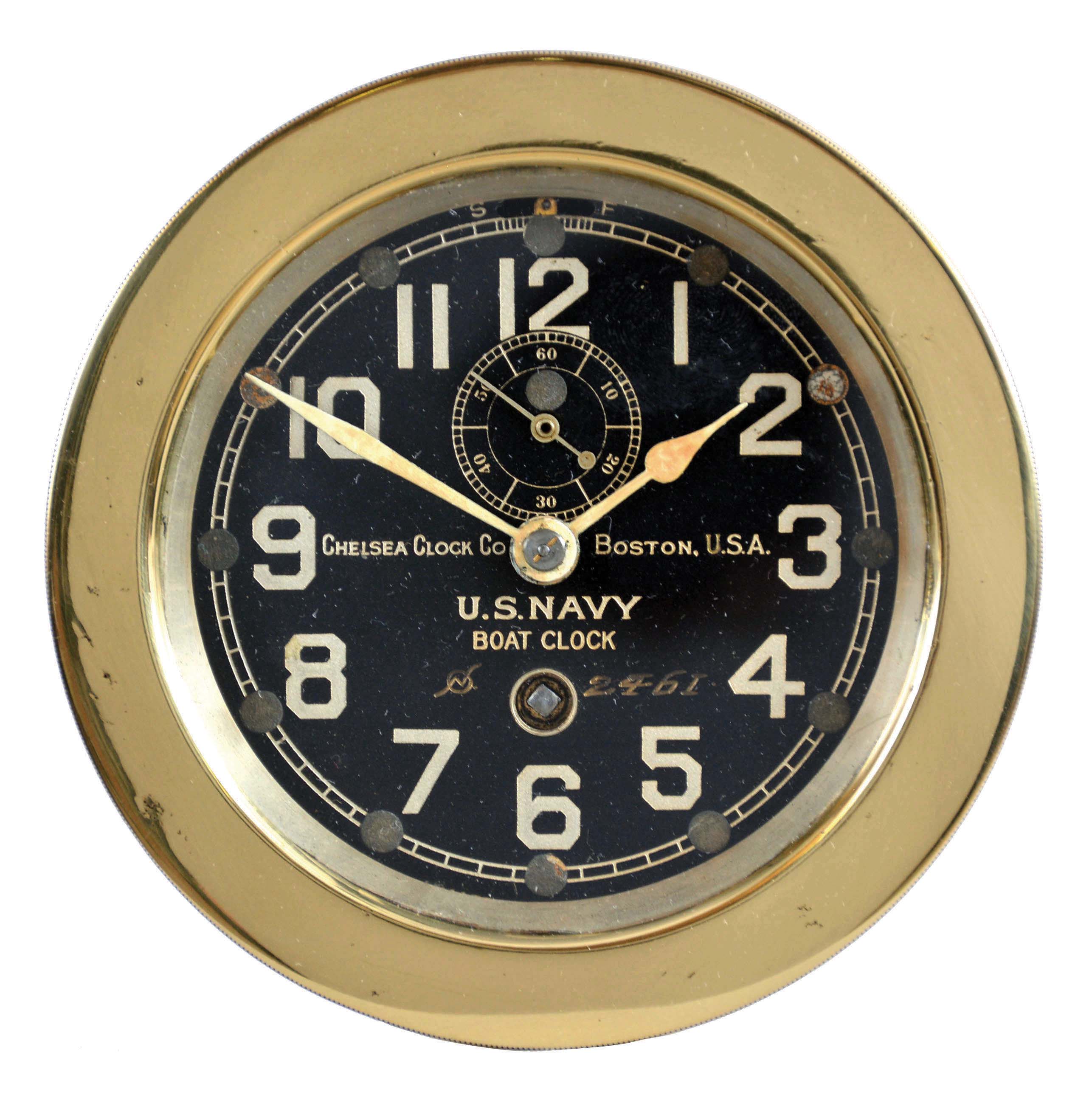 Chelsea Clock Co., Boston, Mass., U.S. Navy Boat Clock, polished brass case with screw on bezel, black dial with silvered Arabic numerals and engraved ordnance department number, 8 day timepiece movement with lever escapement, serial #57760 — Antique Clocks Price Guide