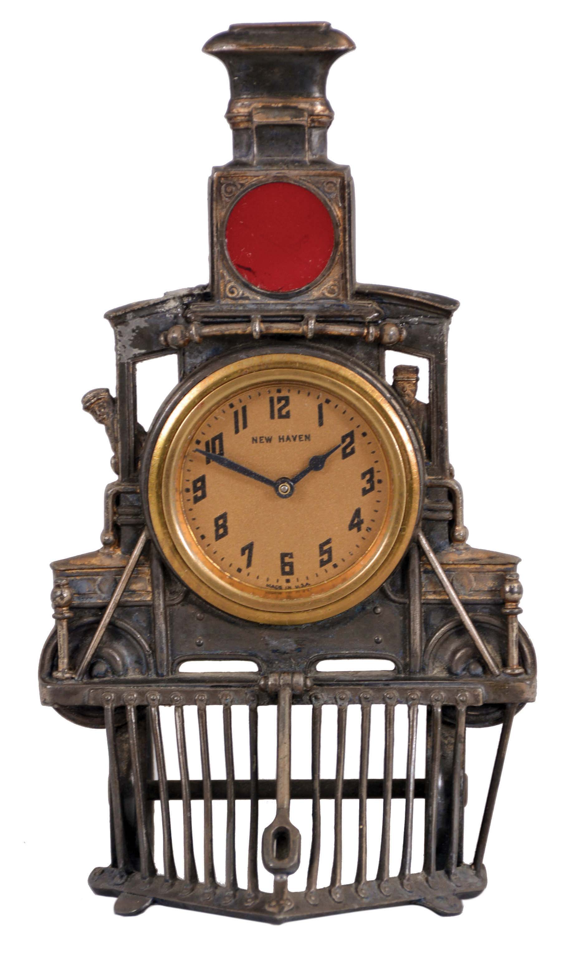 New Haven Clock Co., New Haven, Conn., novelty clock, 30 hour time only movement in a cast metal case resembling the front of locomotive complete with cow catcher and red glass lens, c1920 — Antique Clocks Price Guide
