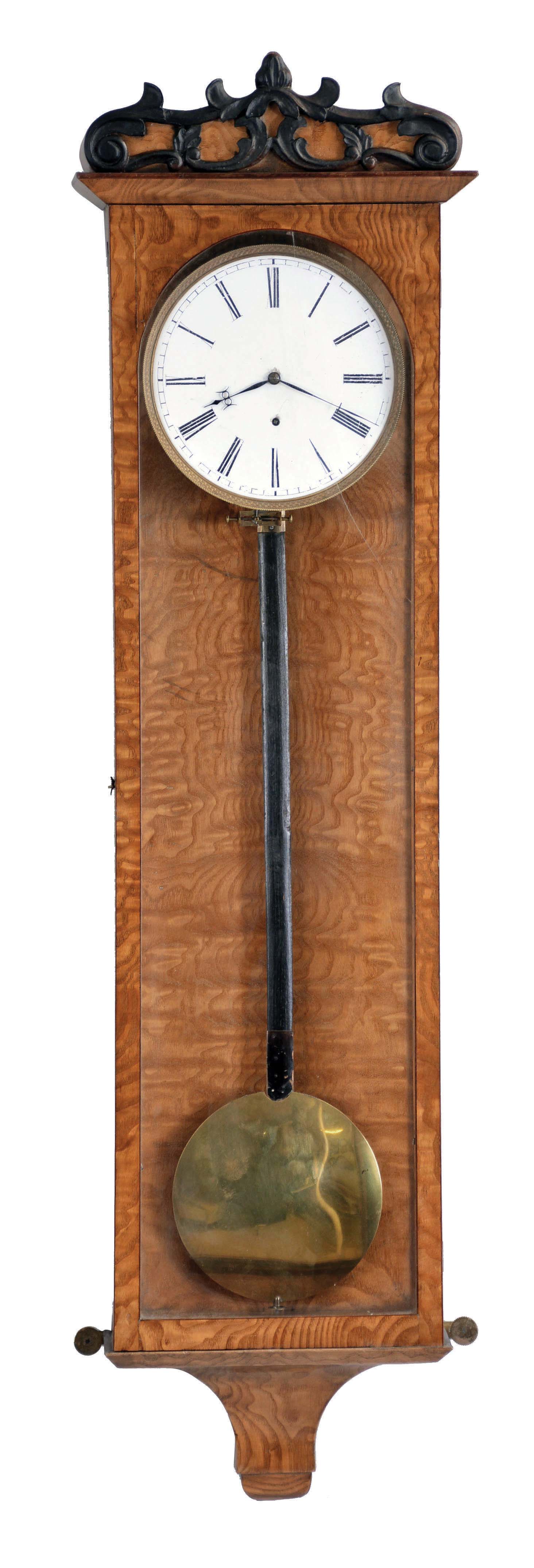 Vienna, Austria, 30 day hanging regulator in the Biedermeier style, rectilinear, 5 light, curly ash veneered case with mahogany stringing, incurved bottom bracket, and beveled projecting cornice, case top with applied, ebonized carving, Roman numeral white enamel dial, finely finished blued steel hands, month going timepiece movement, cylindrical brass weight, and pendulum with ebonized rod and brass ball — Antique Clocks Price Guide