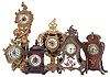 Clocks- 6 (Six): including an Ansonia figural with putto, an Ansonia cartel style, a Hamburg - American with gilt brass case set with porcelain panel featuring putti, a British United with gilt brass case, and two wooden miniatures