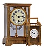 Clocks- 2 (Two) Boston Clock Co.: (1) Boston Clock Co., Chelsea, Mass., "Crystal", 8 day tandem wind, time and strike movement with lever escapement, in a brass case with enamel dial showing Arabic numerals, c1890; (2) Boston Clock Co., Chelsea, Mass., "Queen Anne" carriage clock, 8 day timepiece with platform escapement in a gilt brass case, with three beveled glasses and white enamel dial showing Arabic numerals, c1890.