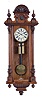 Clocks- 2 (Two): Both Vienna regulators, the first with walnut case and ebonized accents, incurved bottom bracket with gadroon, door with nicely carved half columns and bevelled glass, frieze with applied carving below a projecting cornice, and with carved crest, Roman numeral white enamel dial, pierced hands, and 8 day, weight driven time and strike movement, the other with walnut veneered case, ribbed bottom bracket, door with applied half columns, and two part crest with carved and turned ornament, Roman numeral white enamel dial, pierced hands, and 8 day, weight driven, time and strike movement