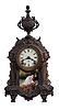 Clocks- 2 (Two): (1) Ansonia Clock Co., New York, NY, "Versailles" mantel clock with a spring driven, 8 day time and half hour strike movement in a cast metal case, c1914. ; (2) New Haven Clock Co., New Haven, Conn., "Winnipeg" hanging clock with a spring driven, 8 day timepiece movement in a walnut case, c1885.