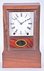 Clocks- 2 (Two): (1) American kitchen clock, time, strike and alarm weight driven movement with reverse painted tablet; (2) Bradley Manf'g. Co., Southington, Conn. cottage clock with a spring driven, 8 day, time and strike movement in a rosewood veneered case, c1855.