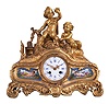 Rollin, a Paris, a gilt bronze mantel clock with porcelain plaques, the base with scroll feet, and richly ornamented in the rococo style, the front set with polychrome enamel porcelain plaques flanking the Roman numeral, white enamel dial, depicting reclining amorini with baskets of flowers, the top also with a pair of well modeled amorini, in a landscape, stealing young birds from a nest, and 8 day, time and strike, pendule de Paris movement