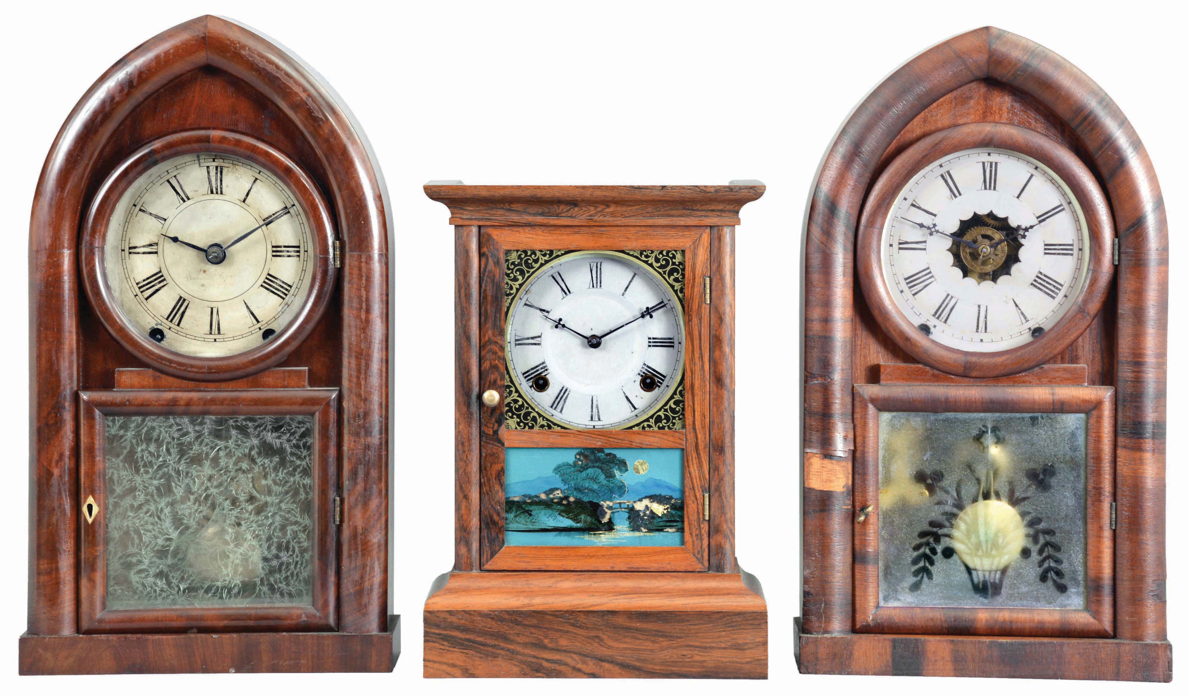 Clocks- 3 (Three): (1) Atkins Clock Co., Bristol, Conn., "Cottage XX" shelf clock with a spring driven, 8 day, time and strike movement in a rosewood veneered case, c1860; (2) Brewster &amp; Ingrahams, Bristol, Conn., "Round Gothic" or "Beehive" shelf clock with a spring (brass) driven, 8 day, time and strike movement in a mahogany veneered case, c1848. (3) William L. Gilbert, Winchester, Conn., "Beehive" shelf clock with a spring driven, 8 day time, strike and alarm movement in a rosewood veneered case, c1850. — Antique Clocks Price Guide