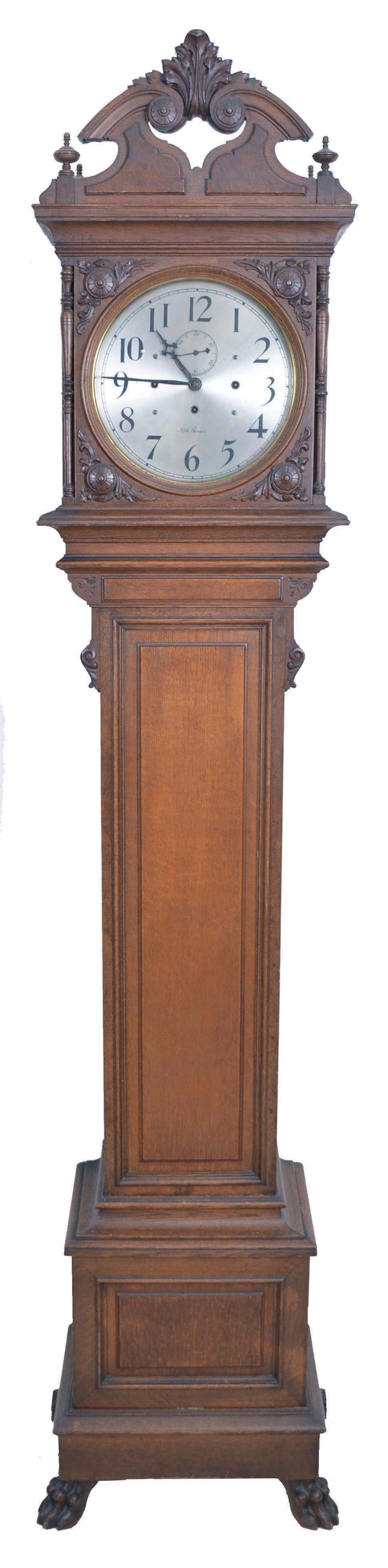 Seth Thomas Clock Co., Thomaston, Conn., "Regulator No. 21" later known as "Hall Clock No. 21", 8 day, time, strike and Westminster chime on bells, weight driven movement with dead beat escapement, in an oak case with carvings, paw feet and silvered brass dial — Antique Clocks Price Guide