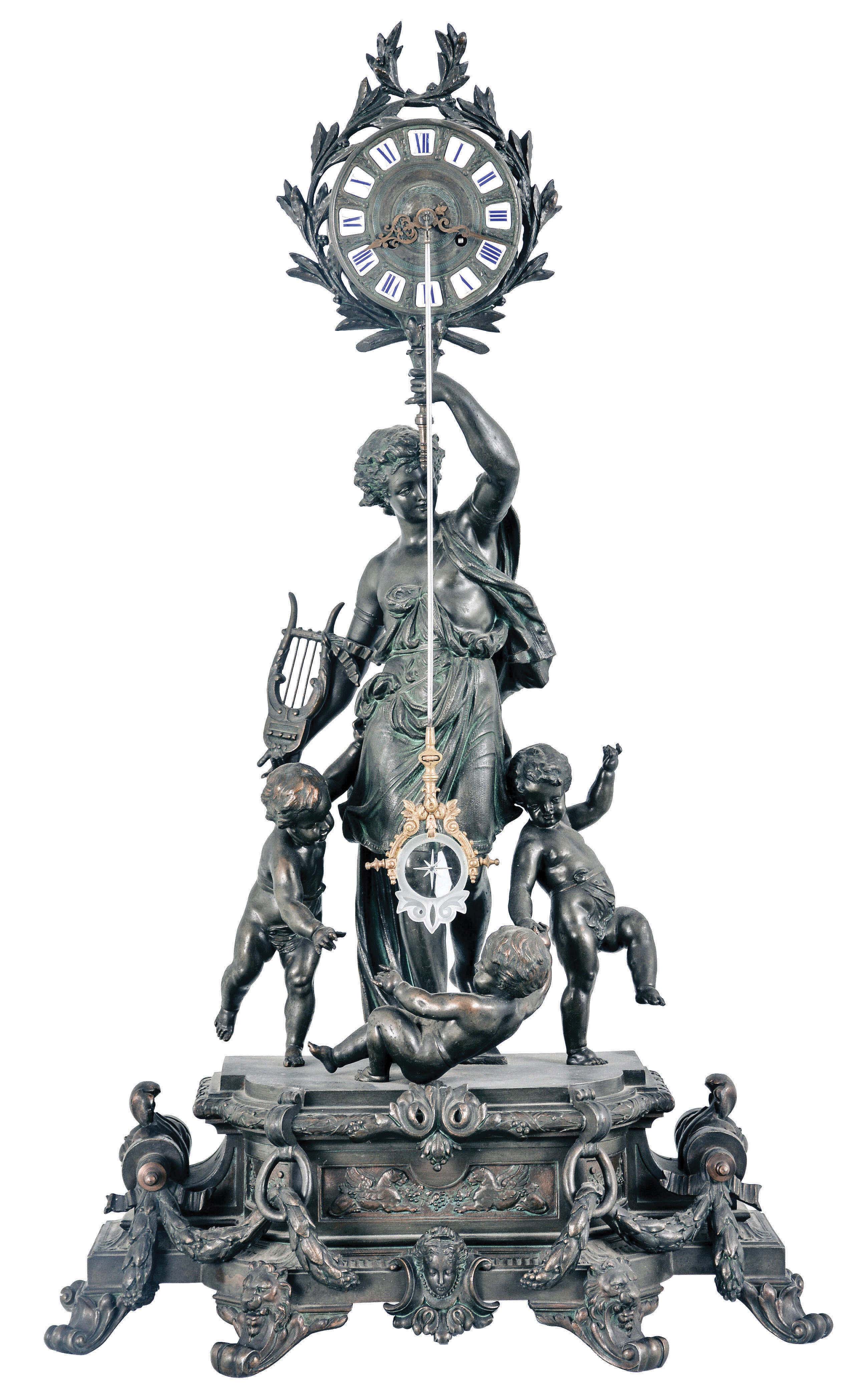 Regnault Fils, Chesnier &amp; Sarrazin, Paris, a large figural mantel clock with front mounted pendulum, the bronzed spelter case with break front base on scroll feet, draped with foliate garlands, and further ornamented with masks, front with relief panel featuring recumbent, addorsed gryphons, and laurel molded, conforming plinth supporting a young male figure, the clock case surrounded by laurel fronds and held aloft in his left hand, a lyre in his right, with three disporting putti at his feet, patinated dial with applied, Roman numeral cartouches, pierced and engraved gilt hands, and with ornamental pendulum oscillating in front of the dial, signed, 8 day, time and strike pendule de Paris movement with Brocot escapement behind the back plate — Antique Clocks Price Guide