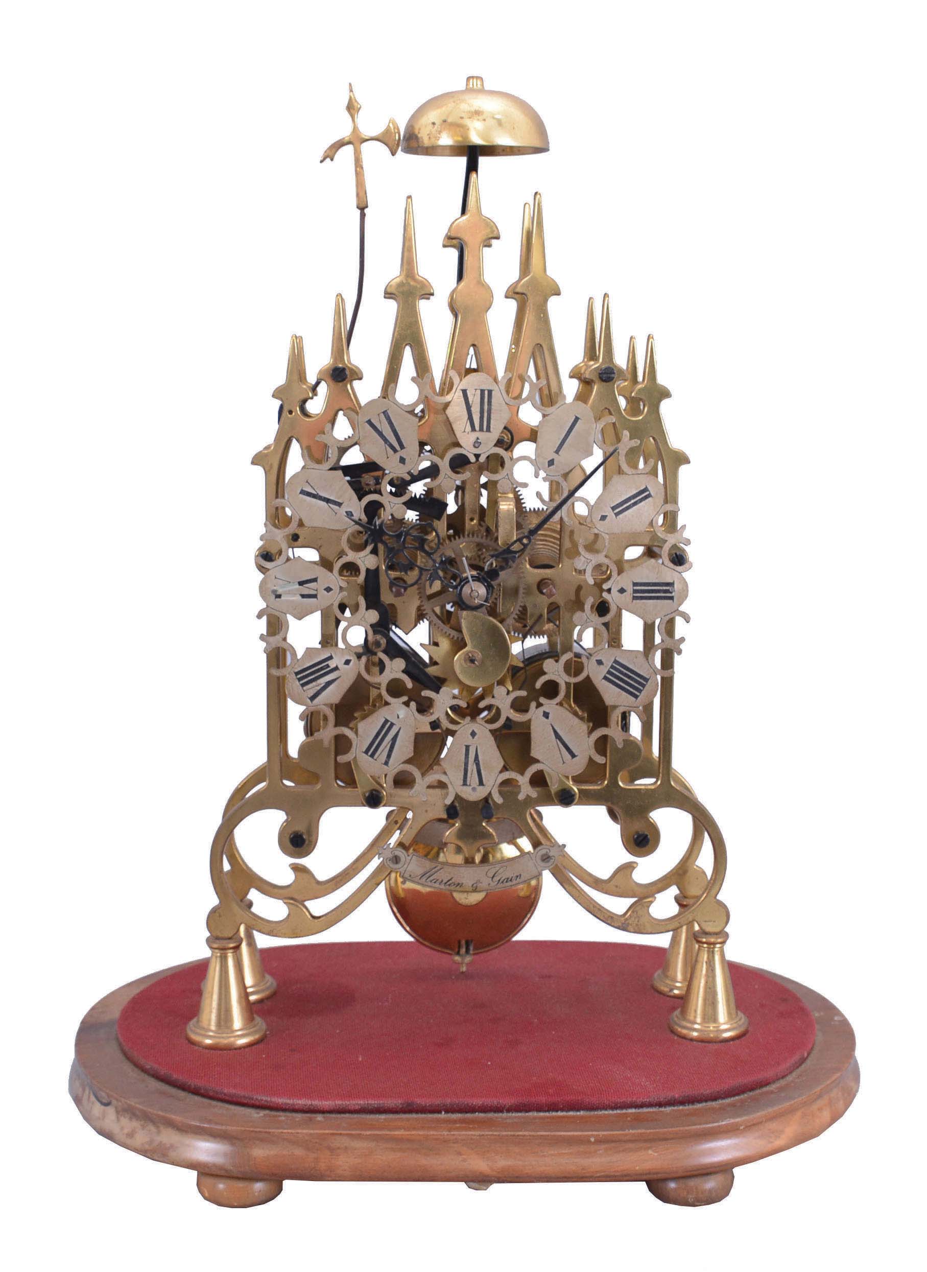 Martin and Gain, Madrid, Spain, 2-fusee skeleton clock, the multi spired Gothic frame of brass is well fretted and polished. This firm launched in Spain to try to meet the resurging interest in skeleton clocks and a general shortage in old merchandise in the 1970's Fusees are with cable rather than chain. Wheels are simple 4-spoke design. Strikes the hours and halves on a central bell. — Antique Clocks Price Guide
