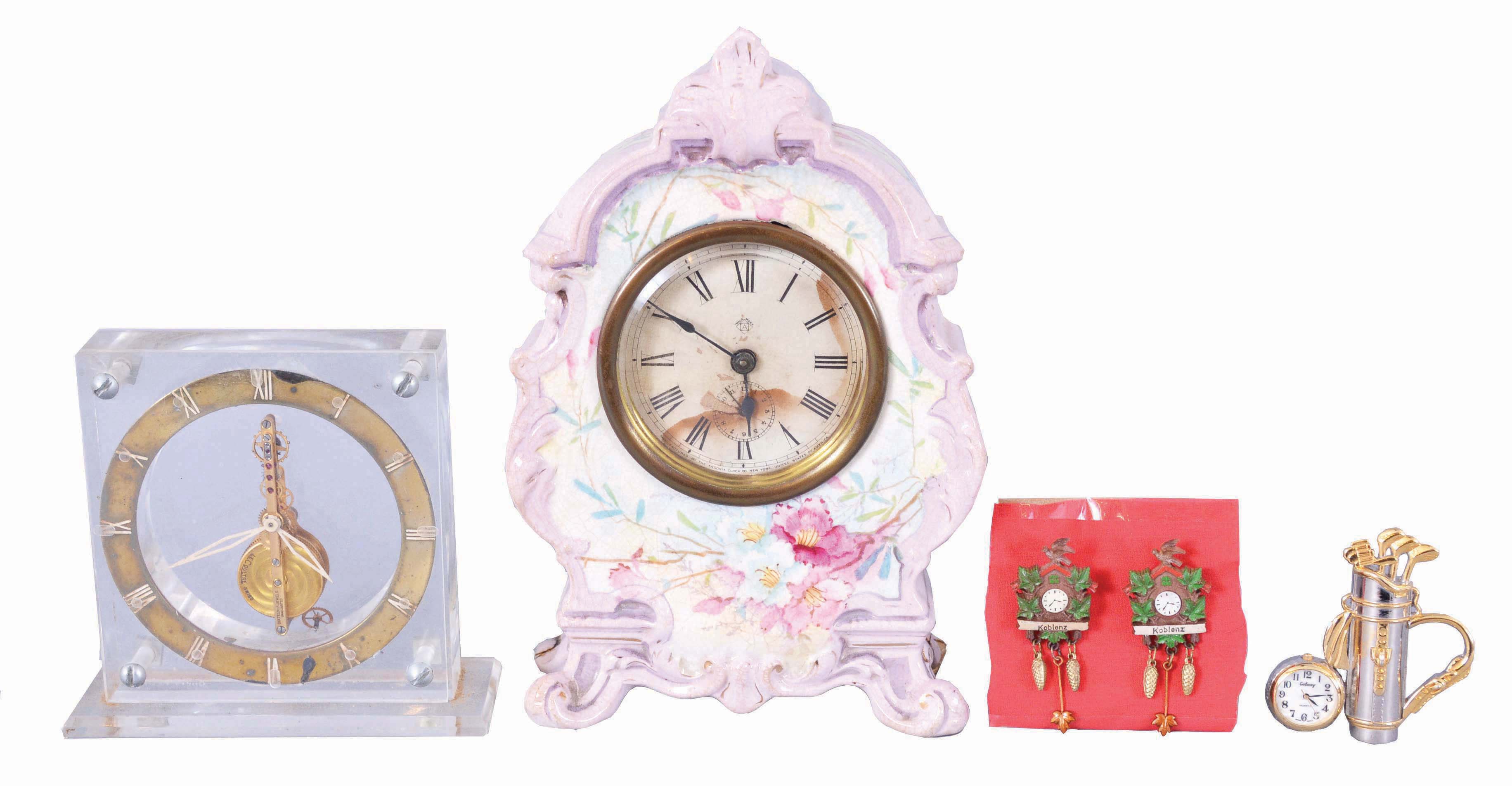 Clocks- 3 (Three): (1) Ansonia Clock Co., New York, miniature porcelain clock, 30 hour, time only in lavender outlined case with floral motif; (2) Switzerland, LeCoultre, desk clock with 16 jewel balance wheel movement in a clear acrylic case. (3) Boardman &amp; Wells, Bristol, Conn., 30 hour, time and strike, weight wood movement half column &amp; splat shelf clock. Lot also comes with a small desk clock in with a golf motif as well as two lapel pins in the shape of cuckoo clocks. — Antique Clocks Price Guide