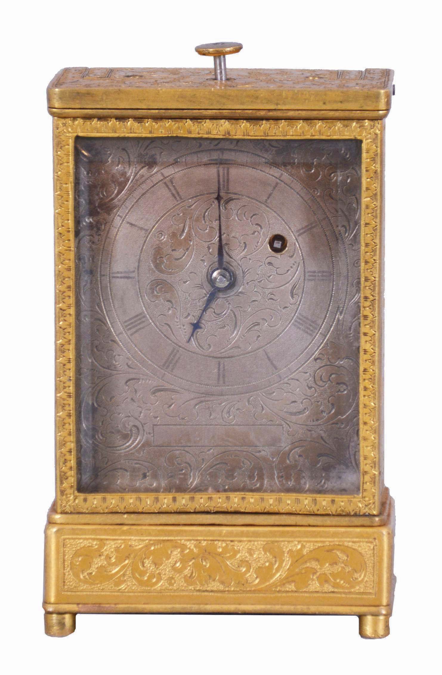 Austria, quarter repeating miniature carriage clock, the rectilinear, gilt brass case on turned feet, front and sides with foliate engraving, carrying handle folding flush with the case top, Roman numeral silvered dial, with engraving matching the case, blued steel hands, round, 30 hour verge fusee movement with blued steel gongs, repeating the last hour and quarter on demand, together with its original leather covered, wooden travel case — Antique Clocks Price Guide