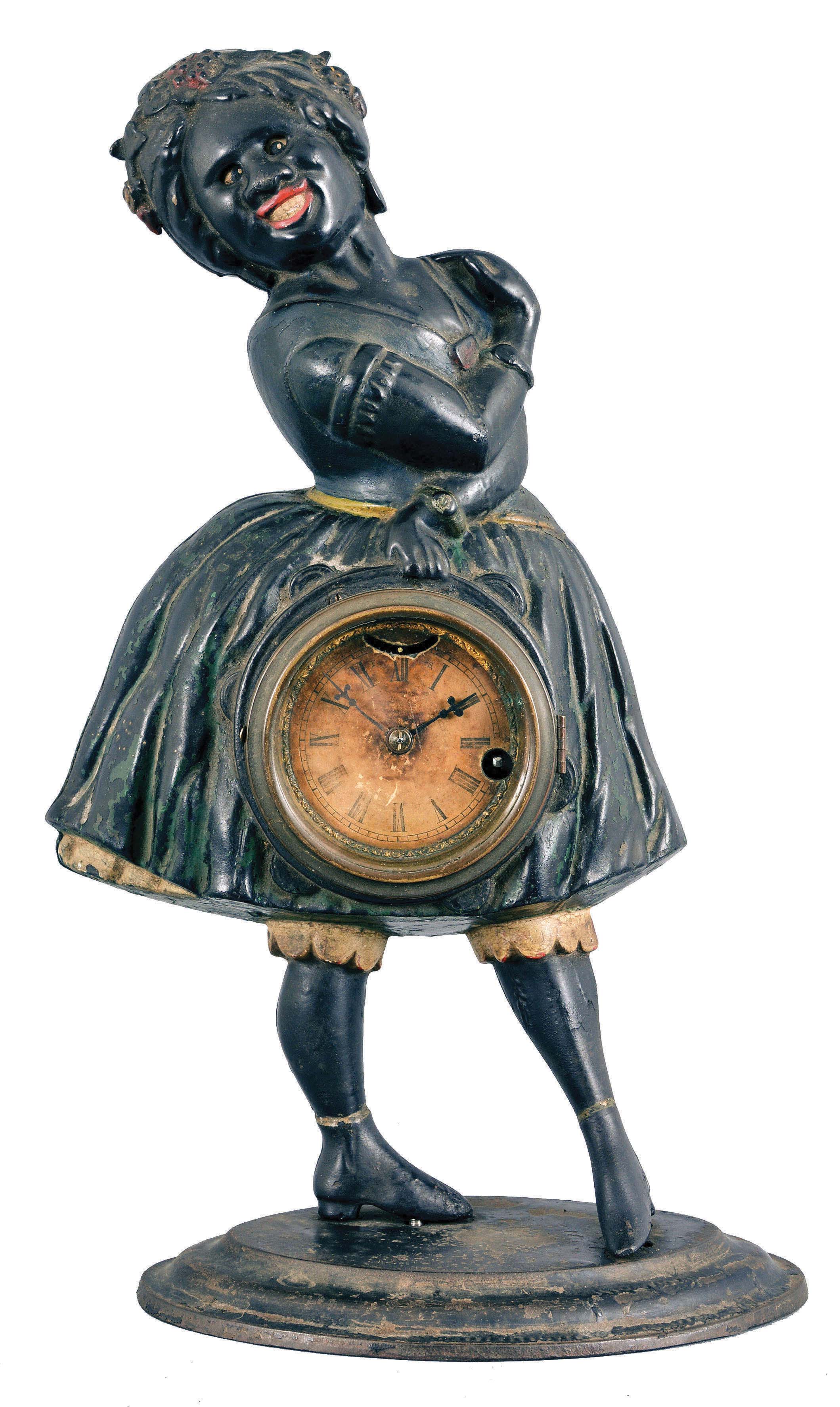 Bradley &amp; Hubbard, Meriden, Conn., for Waterbury Clock Co., "Topsey" blinking eye novelty clock, 30 hour, time and animation, spring driven lever movement in a cast iron case depicting a smiling female figure with dress, blouse, stockings and shoes, 3 inch paper dial with Roman numerals. — Antique Clocks Price Guide