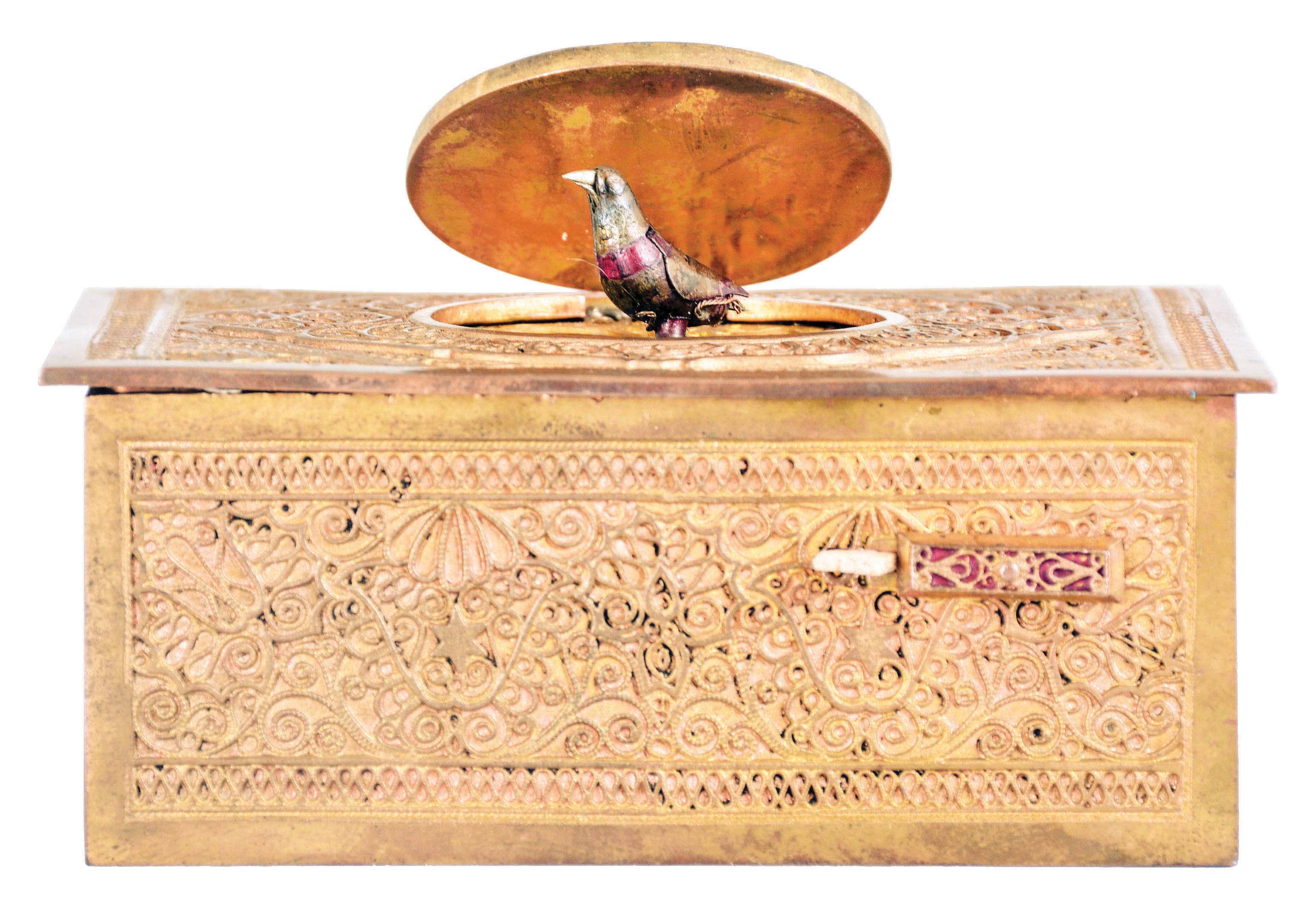 Germany, probably Karl Griesbaum, singing bird box, gilt brass case with ornate filigree applique, the front with slide for activating the bird, appearing from beneath the oval cover and performing on demand, 20th century — Antique Clocks Price Guide