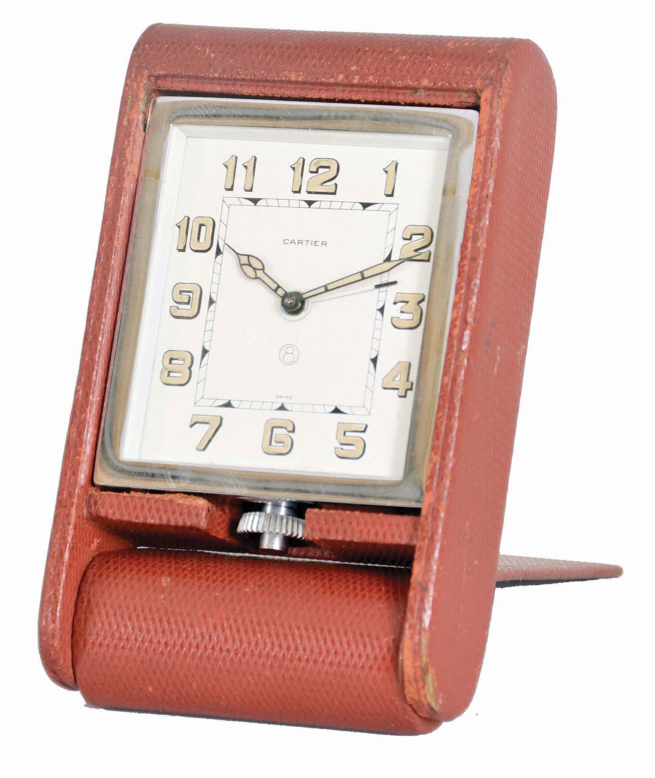Cartier Folding Travel Clock in red leather case with dial signed "Cartier", "Swiss" and "8", radium Arabic numeral dial, radium hour and minute hands, eight-day time and alarm movement with pointer alarm hand set in a nickel case with lower winding/setting stem. — Antique Clocks Price Guide