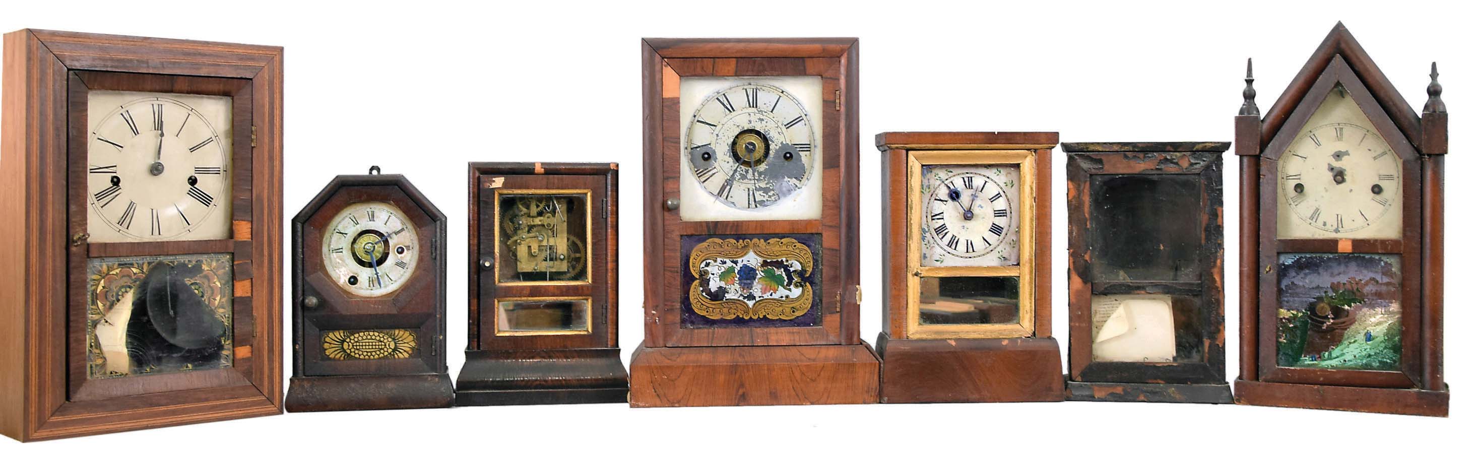 Clocks- 7 (Seven): (1) Elisha Manross, Bristol, shelf clock with a spring driven 30 hour time and strike movement in a rosewood veneered case with inlay, c1850; (2) Seth Thomas, Plymouth Hollow, Conn., cottage shelf clock with a spring driven 30 hour time and alarm movement in a rosewood veneered case, c1850. (3): Brewster &amp; Co., Bristol, Conn., cottage shelf clock with a spring driven 30 hour time and alarm movement in a rosewood veneered case, c1850. (4) Seth Thomas, Plymouth Hollow, Conn., cottage shelf clock with a spring driven 30 hour time and strike movement in a rosewood veneered case, c1850. (5) Daniel Pratt, Reading, Mass., cottage clock with a spring driven 30 hour timepiece movement in a rosewood veneered case, c1855. (6) S. B. Terry, Terryville, Conn., shelf clock with a 30 hour timepiece movement (incomplete) in a paper finished case, c1850. (7) Waterbury Clock Co., Waterbury, Conn. steeple shelf clock with a spring driven 30 hour time and strike case in a mahogany veneered case, c 1855. — Antique Clocks Price Guide