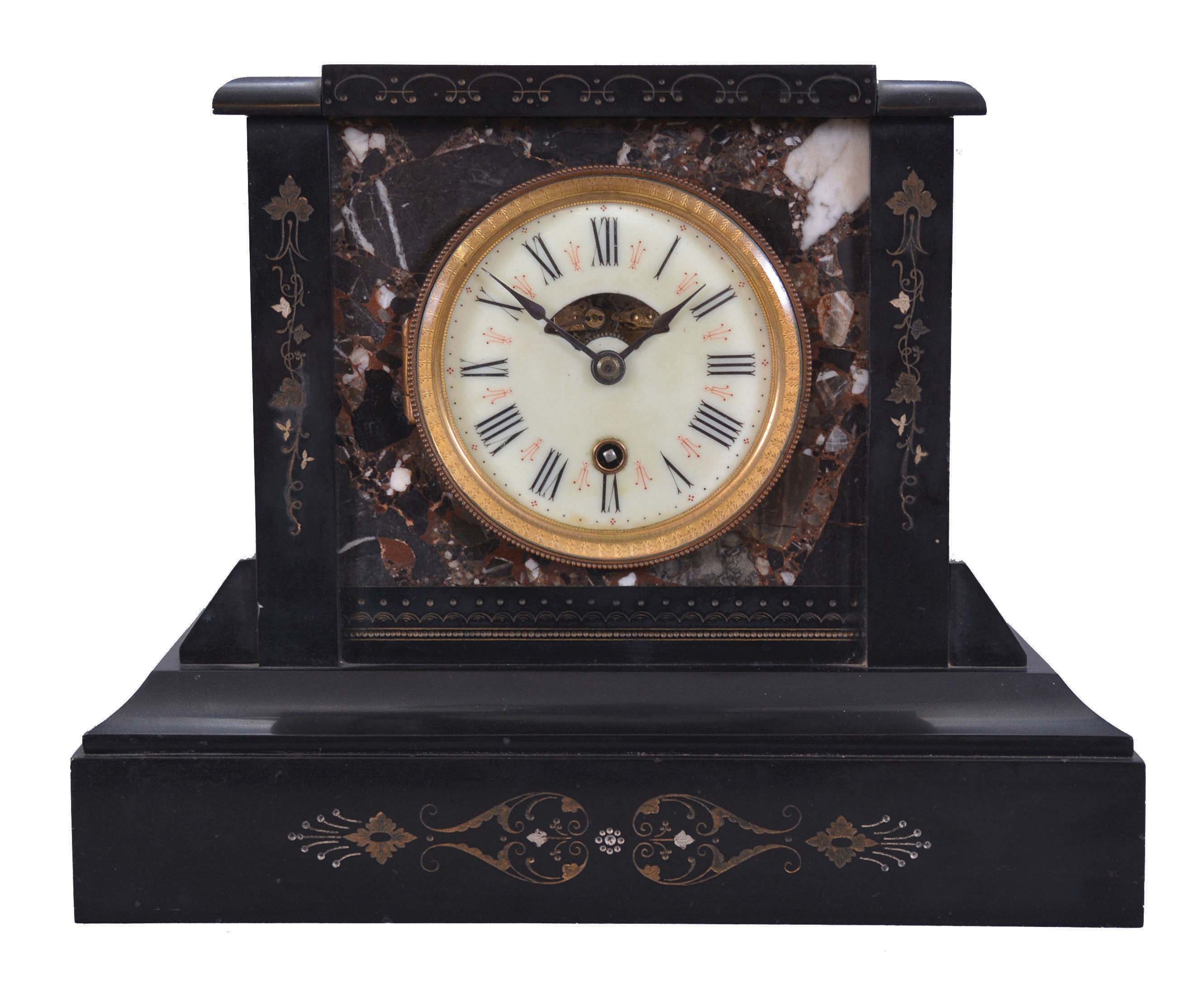 Boston Clock Co., Boston, Mass., mantel clock, 8 day, time and strike, tandem-wind movement in a black slate case with multicolor marble inserts, porcelain dial with aperture to view balance wheel escapement. — Antique Clocks Price Guide