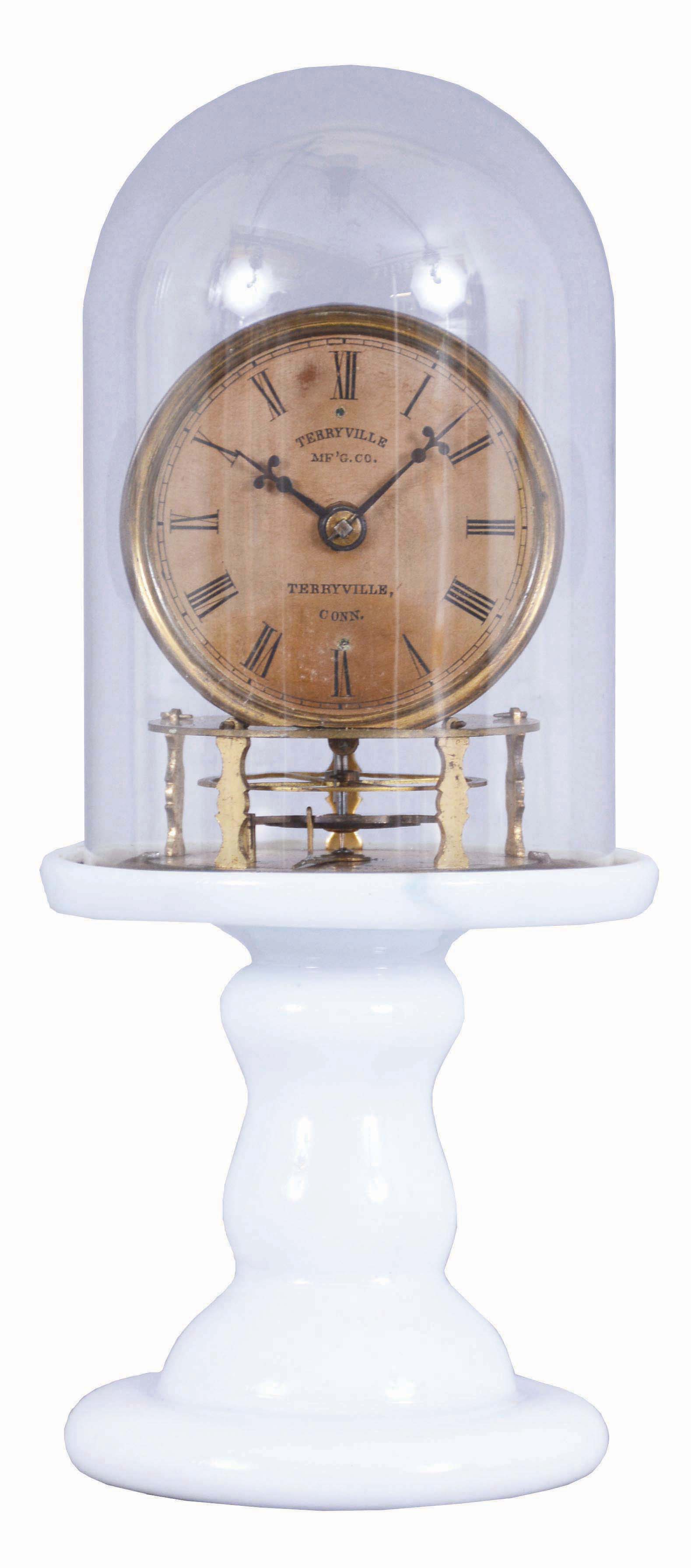 Terryville Manufacturing Company, Terryville, Connecticut Candlestand Clock c. 1855, with 2 3/4-inch paper on zinc dial signed Terryville Mfg. Co., Terryville, Conn., thirty-hour timepiece with four arm balance wheel, hairspring, and regulator below the movement, back plate stamped, Terryville Manufacturing Company, Terryville, Conn., Patented October 5th, 1852, milk glass pedestal and glass dome — Antique Clocks Price Guide