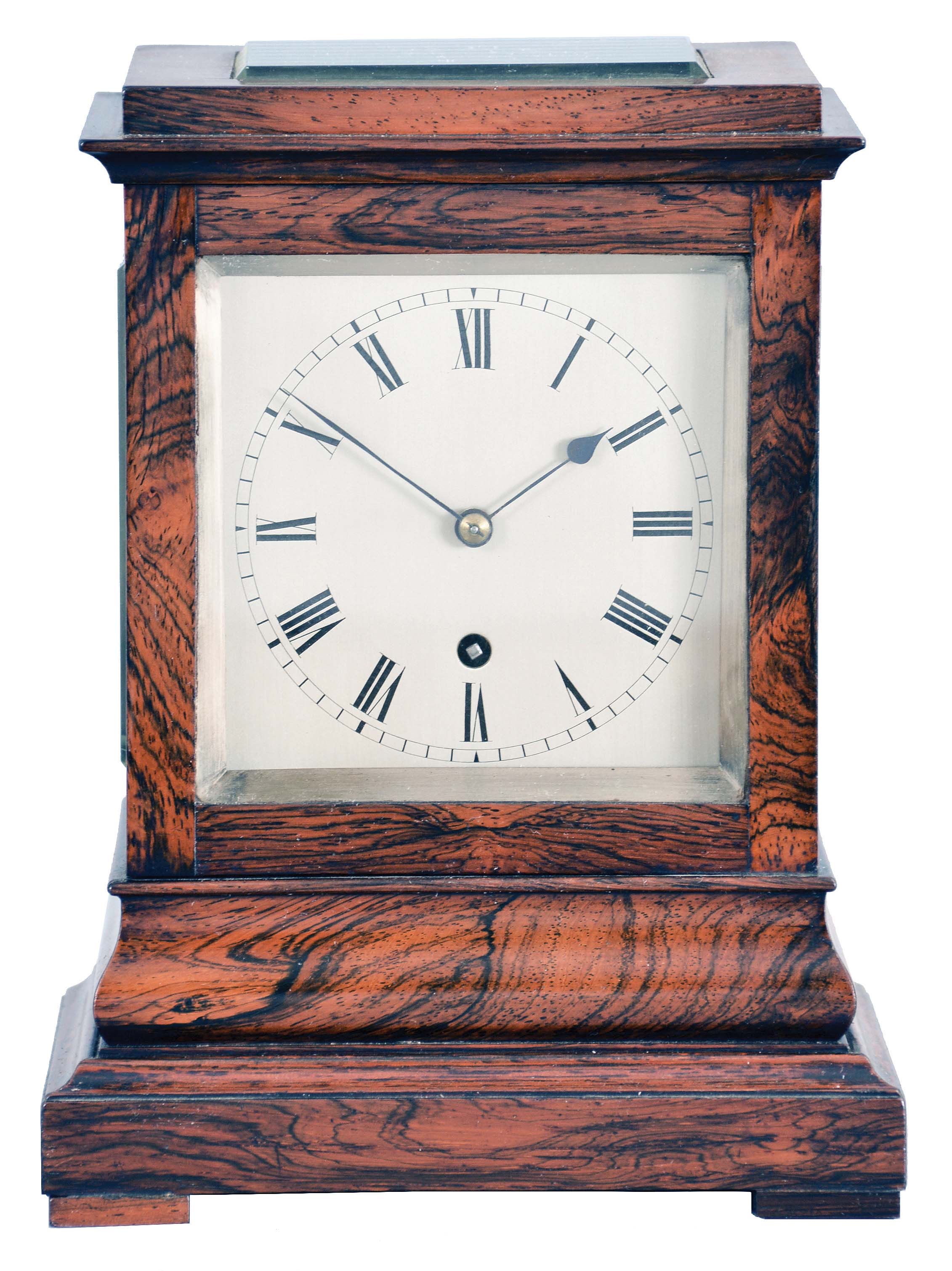 England, a miniature rosewood bracket form fusee timepiece, the glazed, architectural case with footed, molded base supporting a bombe surface the upper, rectilinear portion with cavetto cornice molding, Roman numeral silvered dial with blued spade and whip hands, the door with matching, silvered liner, 8 day, brass timepiece movement with recoil escapement, and brass pendulum with tie down for transport — Antique Clocks Price Guide