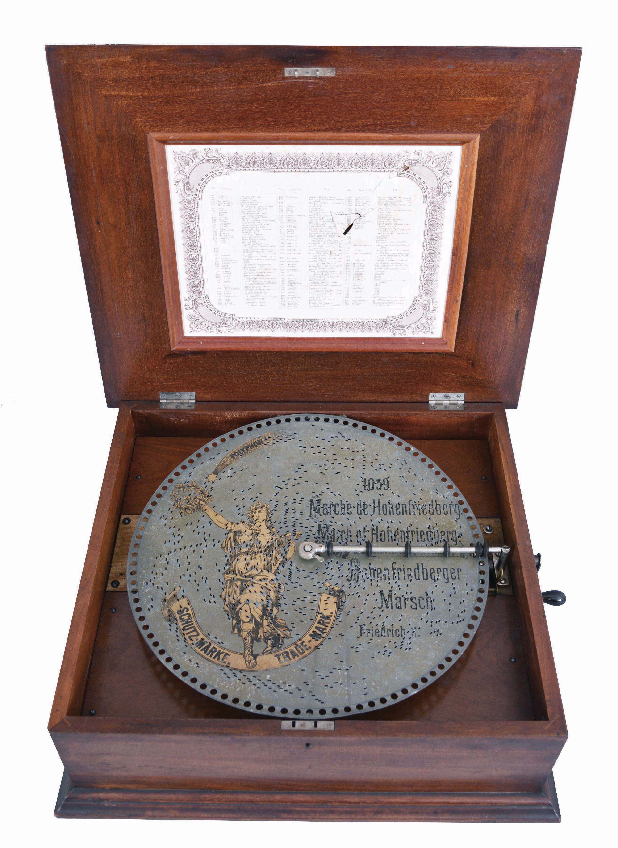 Germany, Polyphon Musikwerk, 39.8cm or 15 1/2 inch disc playing music box, style 43 variant [single comb with going barrel movement [not a coil spring], in a nicely figured mahogany case, plain, with raised molding to lid, and an insert inside lid showing available tunes. With 7 Polyphon discs, including the Star Spangled Banner (Das sternfunkelnde Banner) Note this box will play Regina 15 1/2 inch discs also, see separate lot of 125 Regina discs. — Antique Clocks Price Guide