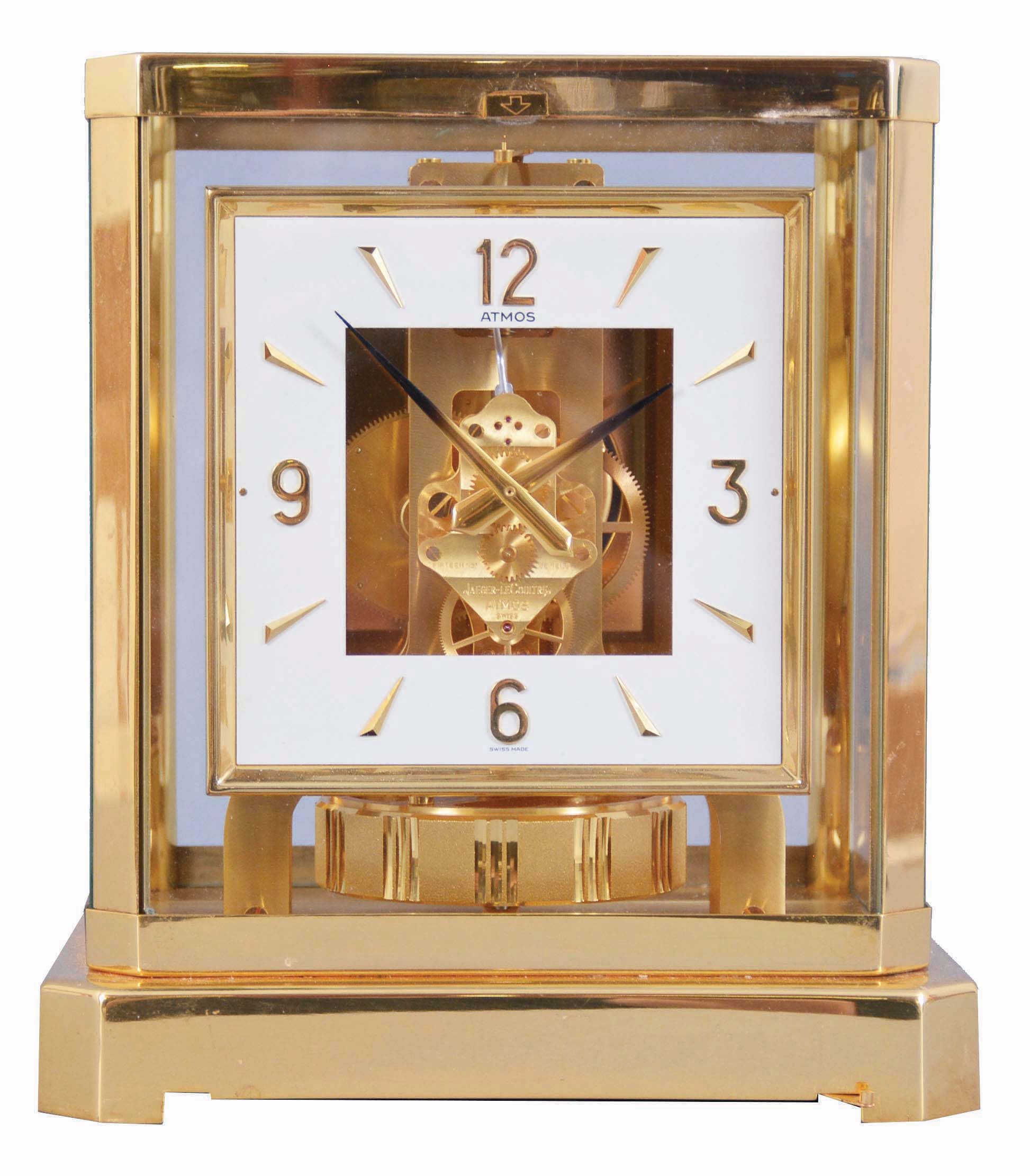 Jaeger- LeCoultre, Switzerland, "Atmos" clock, 15 jewel movement, gilt torsion pendulum, square white painted dial with applied gilt Arabic numerals and arrow markers, gilt hands with black painted tips, all contained in a glazed rectangular case with removable front panel, serial #561214, c1983. — Antique Clocks Price Guide
