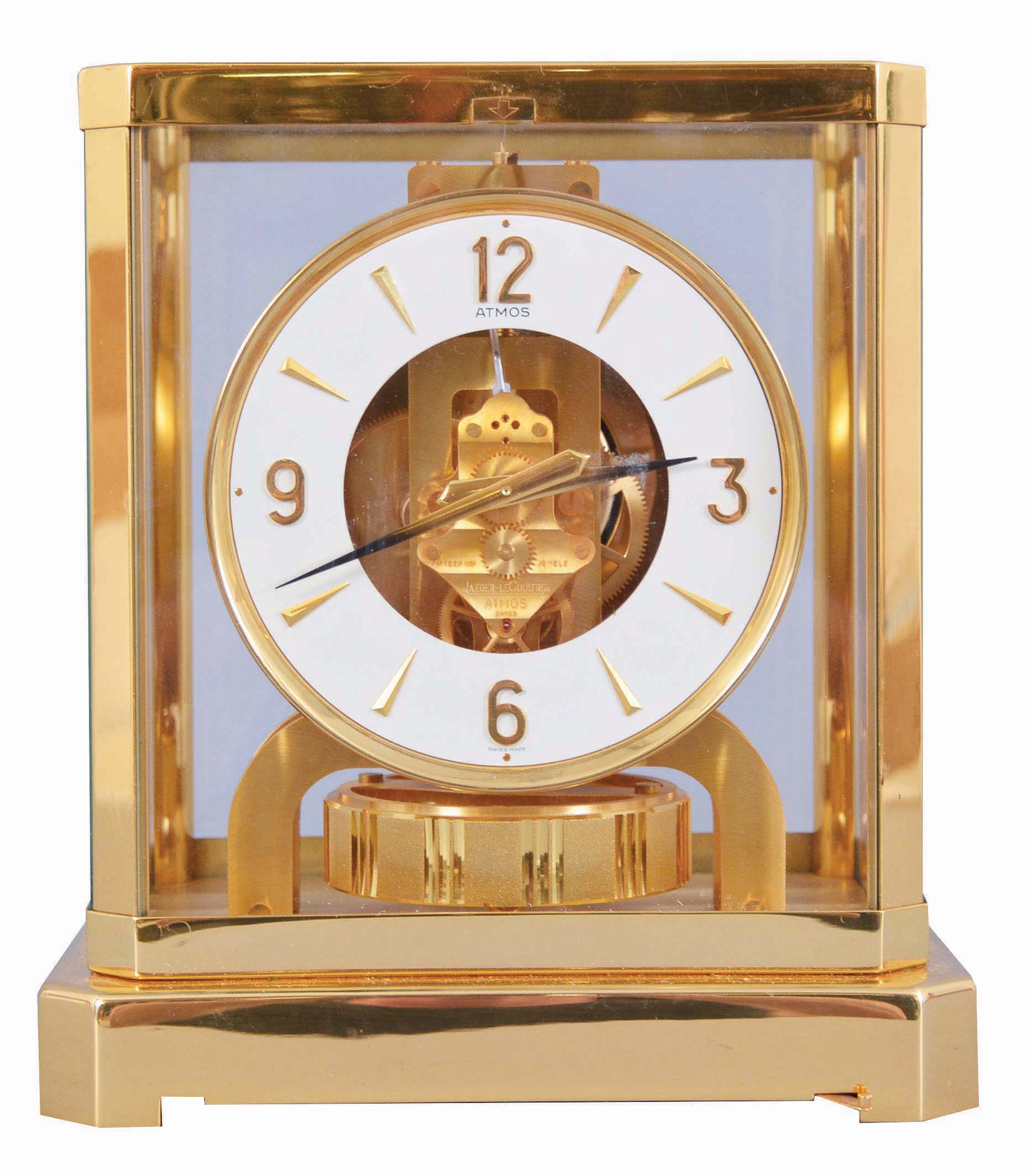 Jaeger- LeCoultre, Switzerland, "Atmos" clock, 15 jewel movement, gilt torsion pendulum, round white painted dial with applied gilt Arabic numerals and arrow markers, gilt hands with black painted tips, all contained in a glazed rectangular case with removable front panel, serial #506271, c1979. — Antique Clocks Price Guide