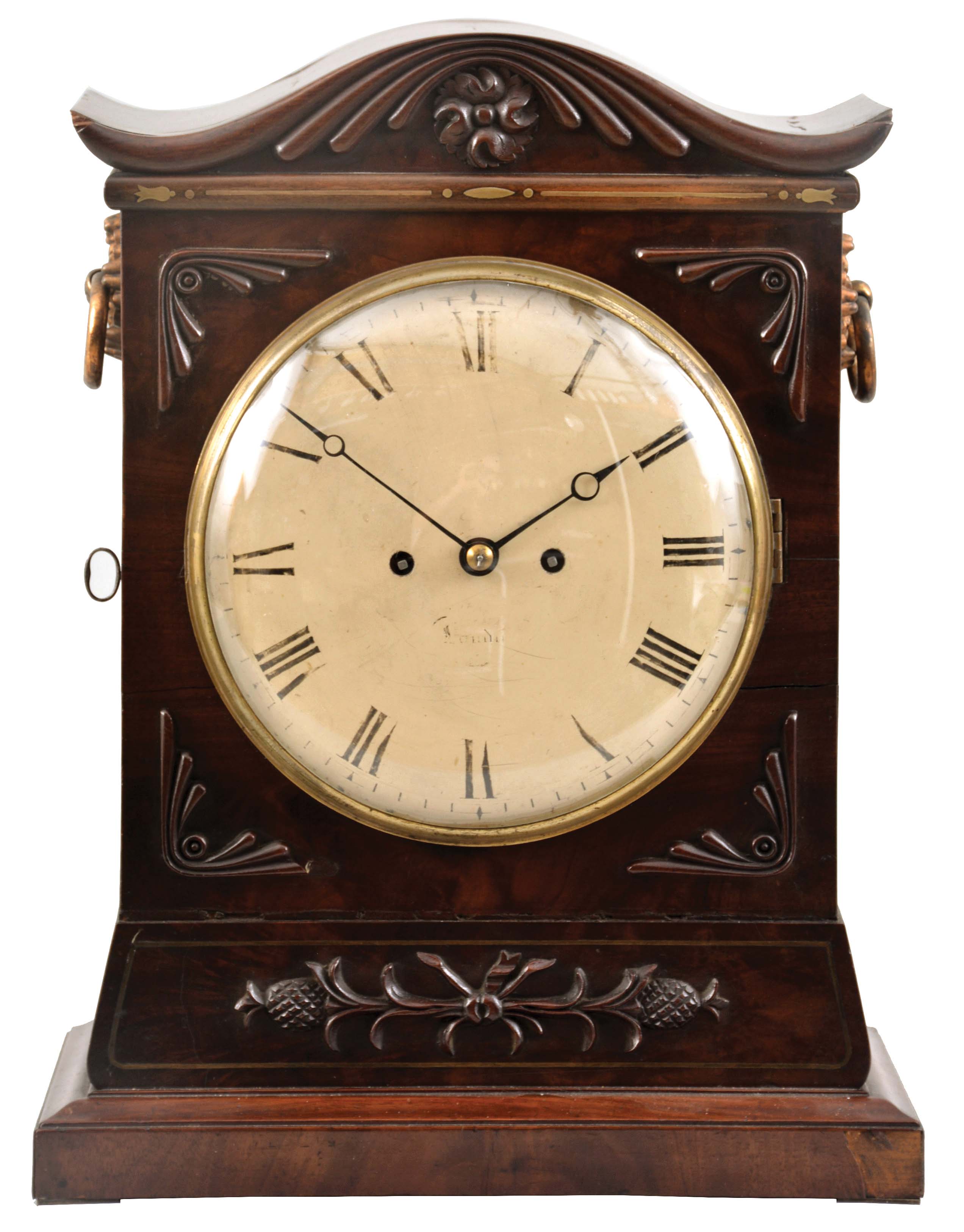 Mackduff, London, a Regency two train bracket clock, brass inlaid mahogany case with applied carved ornament and serpentine top, the sides with brass fish scale frets and ring handles with stamped rosettes, brass bezel with convex glass, Roman numeral white enamel dial blued steel Breguet style hands, 8 day, time and strike brass fusee movement with shouldered plates, counting the hours on a bell — Antique Clocks Price Guide