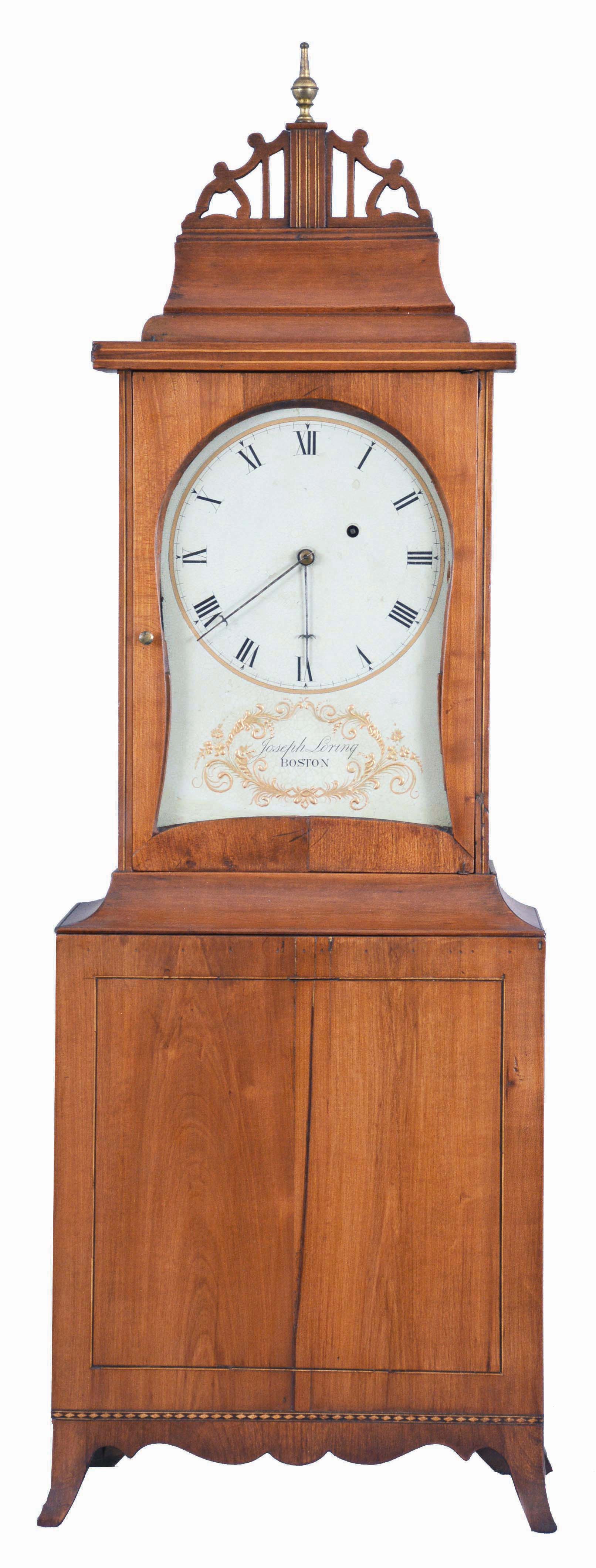 Joseph Sterling, Boston, Massachusetts, cherry cased kidney dial shelf clock, with molded top, central inlaid plinth and pierced fret, glazed kidney dial opening surmounts the line and alternating dark and light inlaid base, with scalloped apron and French feet, eight day time only brass movement with lead weight, brass-faced pendulum and iron rod. — Antique Clocks Price Guide