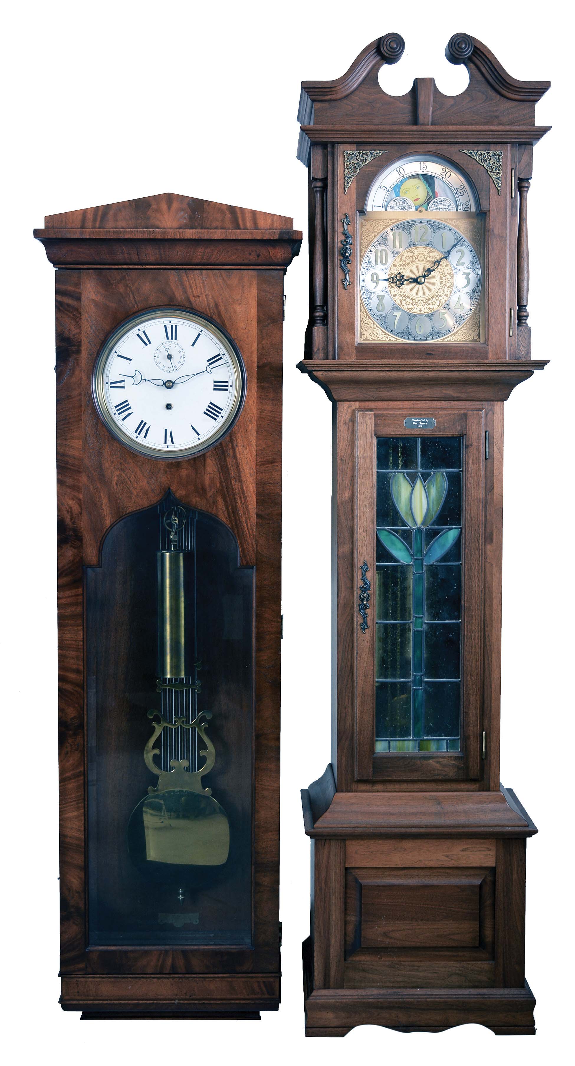 2 (Two) Modern: (1) Colonial Clock Co., Zeeland, MI, reproduction pinwheel jeweler's regulator in a mahogany veneer case with beveled glass door. Colonial copied the French regulator hanging in Sir John Bennett's Clock Shop at Greenfield Village, MI. (2) Emperor tall clock time, strike and chime, weight driven movement in a walnut case with purpose made leaded stained glass panel on door built by Gus Chinery, 1975 — Antique Clocks Price Guide