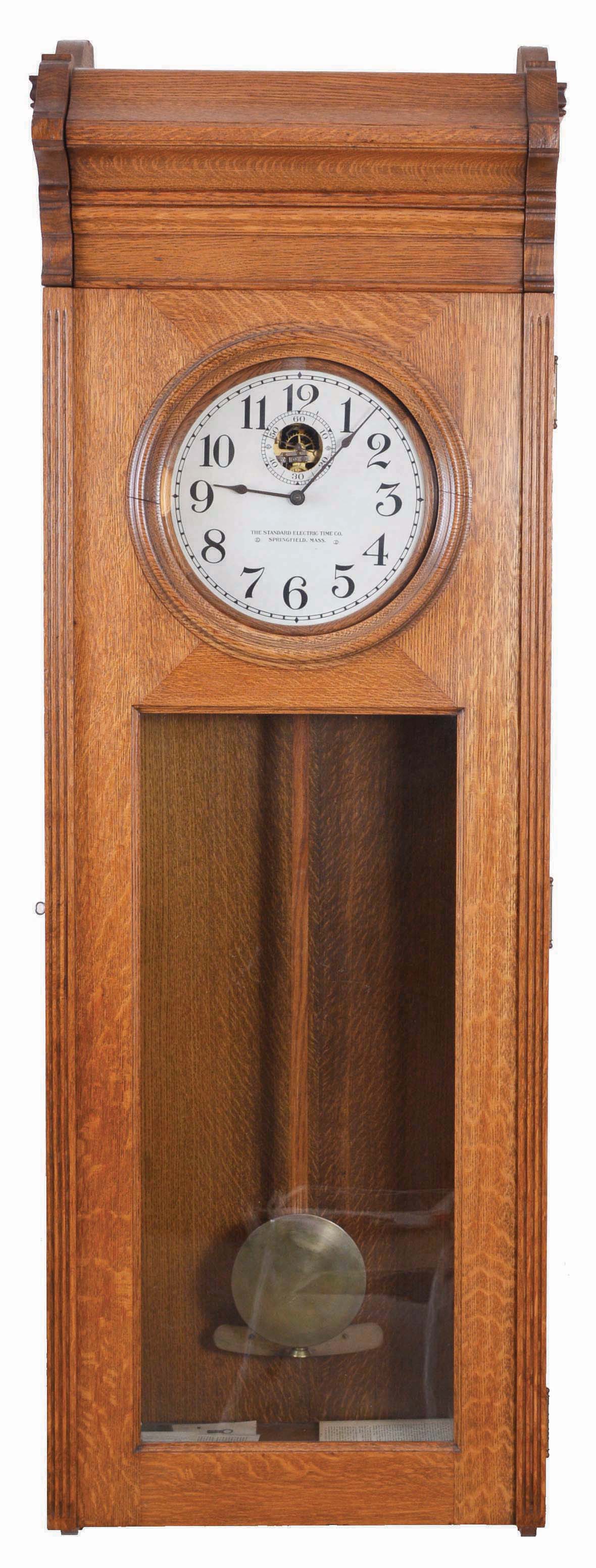 Standard Electric Time Co., Springfield, Mass., "Master Clock" wall clock, electrically driven, time only movement producing electrical impulse to drive a slave or slaves, one of which is included. The clock is housed in a heavy oak case and has painted metal dial. — Antique Clocks Price Guide