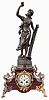 Anaclet, AngoulIme, figural mantel clock, 8 day, spring driven, time and strike, dark red marble base on gilt rococo feet holding a cream porcelain dial with Roman numerals and gilt hands, topped with a signed patinated cast spelter figure of woman beside a harp titled "La Symphonie" with a pendule de Paris movement signed by Mougin.