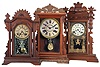 Clocks- 3 (Three): (1) E. Ingraham & Co.,Bristol, Conn., "Cartoon" shelf clock with a spring driven, 8 day, time and strike movement in a walnut case, c1889; (2) E. Ingraham & Co., Bristol, Conn., "Farren" premium model made for Farren Brothers shelf clock with a spring driven, 8 day, time and strike movement in a walnut case, c1880. (3) E. Ingraham & Co., Bristol, Conn., "Ingot" shelf clock with a spring driven, 8 day, time and strike movement in a walnut case, c1896.