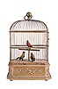 France, attributed to Bontems, automata with three caged, singing birds, the gilt cage having a rectangular wooden base with canted corners, decorated with foliate ornament, and containing the keywound mechanism, the cage containing brightly colored, life size songbirds who vocalize, turn their heads and flick their tails in turn when activated