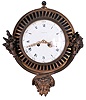 Gilt Brass Cartel Wall Clock with 7.5 inch porcelain roman numeral dial marked "Tiffany" and "France", pierced gilt hands all set in a cast brass fluted case with overflowing cornucopias of flowers and fruit at the sides and a mythological god of plenty mask at the bottom, eight-day French spring powered movement with lever platform escapement and bell strike.