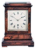 England, a miniature rosewood bracket form fusee timepiece, the glazed, architectural case with footed, molded base supporting a bombe surface the upper, rectilinear portion with cavetto cornice molding, Roman numeral silvered dial with blued spade and whip hands, the door with matching, silvered liner, 8 day, brass timepiece movement with recoil escapement, and brass pendulum with tie down for transport