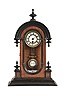 Germany, a miniature Vienna style shelf timepiece, walnut arch top case with ebonized base and arch moldings, turned, ebonized drops and finials, the door with glazed, oblong, molded aperture, Roman numeral white enamel dial, blued steel spade hands, 8 day time only spring driven movement, and faux compensated R/A pendulum