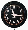 Glo-Dial Clock Company, Los Angeles, California, neon gallery wall clock, electric driven, time only movement with large 25.5in black dial, bold straight white hands, Arabic numerals and orange lighted neon perimeter