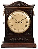 Mackduff, London, a Regency two train bracket clock, brass inlaid mahogany case with applied carved ornament and serpentine top, the sides with brass fish scale frets and ring handles with stamped rosettes, brass bezel with convex glass, Roman numeral white enamel dial blued steel Breguet style hands, 8 day, time and strike brass fusee movement with shouldered plates, counting the hours on a bell