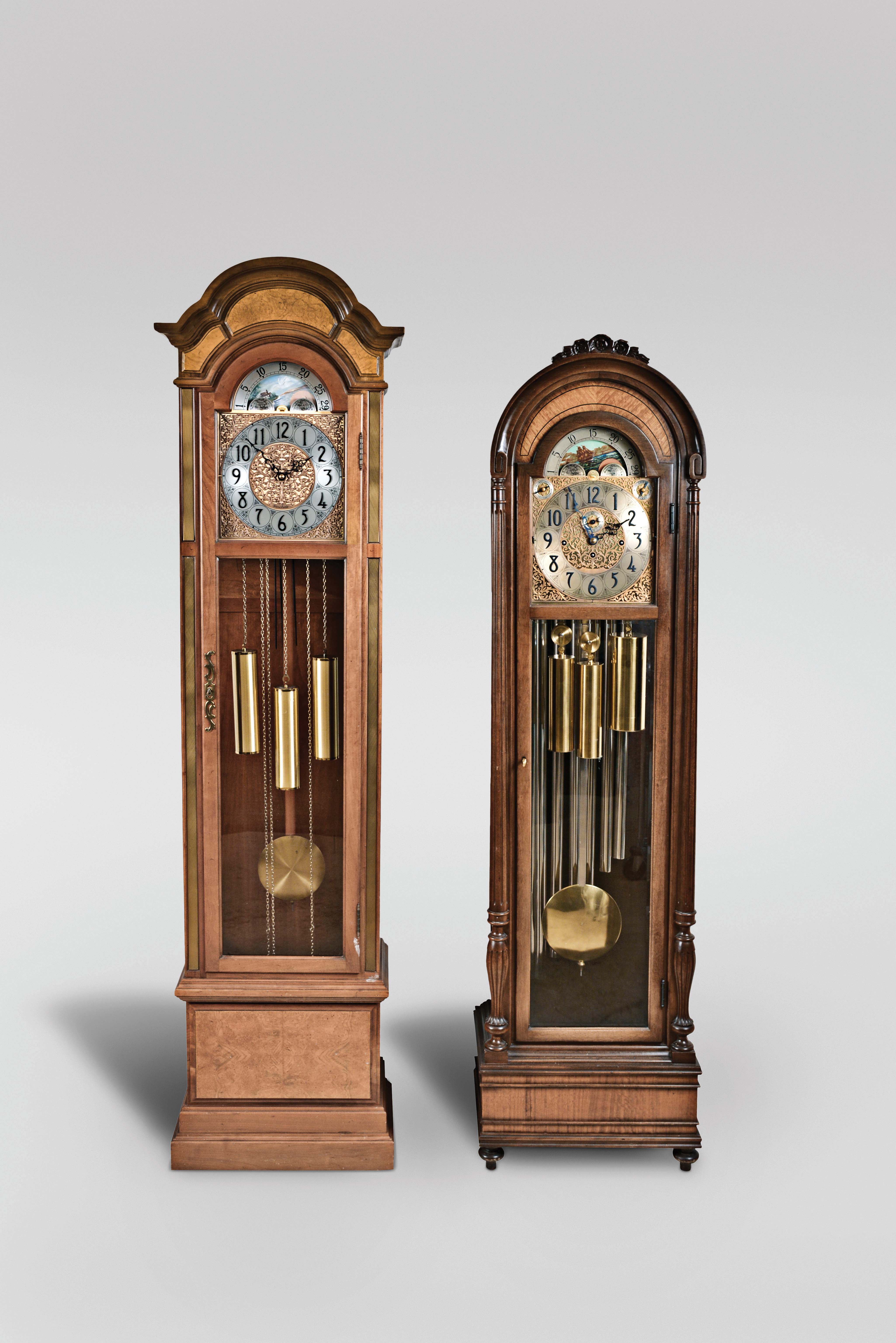 Tall Clocks- 2 (Two) Herschede Clock Co., Cincinnati Ohio, 8 day, time, strike and chime, weight driven movement with moon phase: (1) quarter hour chiming on gongs in cherry and glass case with ash burl highlights; (2) playing three tunes, Westminster, Whittington and Canterbury on 9 tubes in a mahogany case with satinwood highlights. — Antique Clocks Price Guide