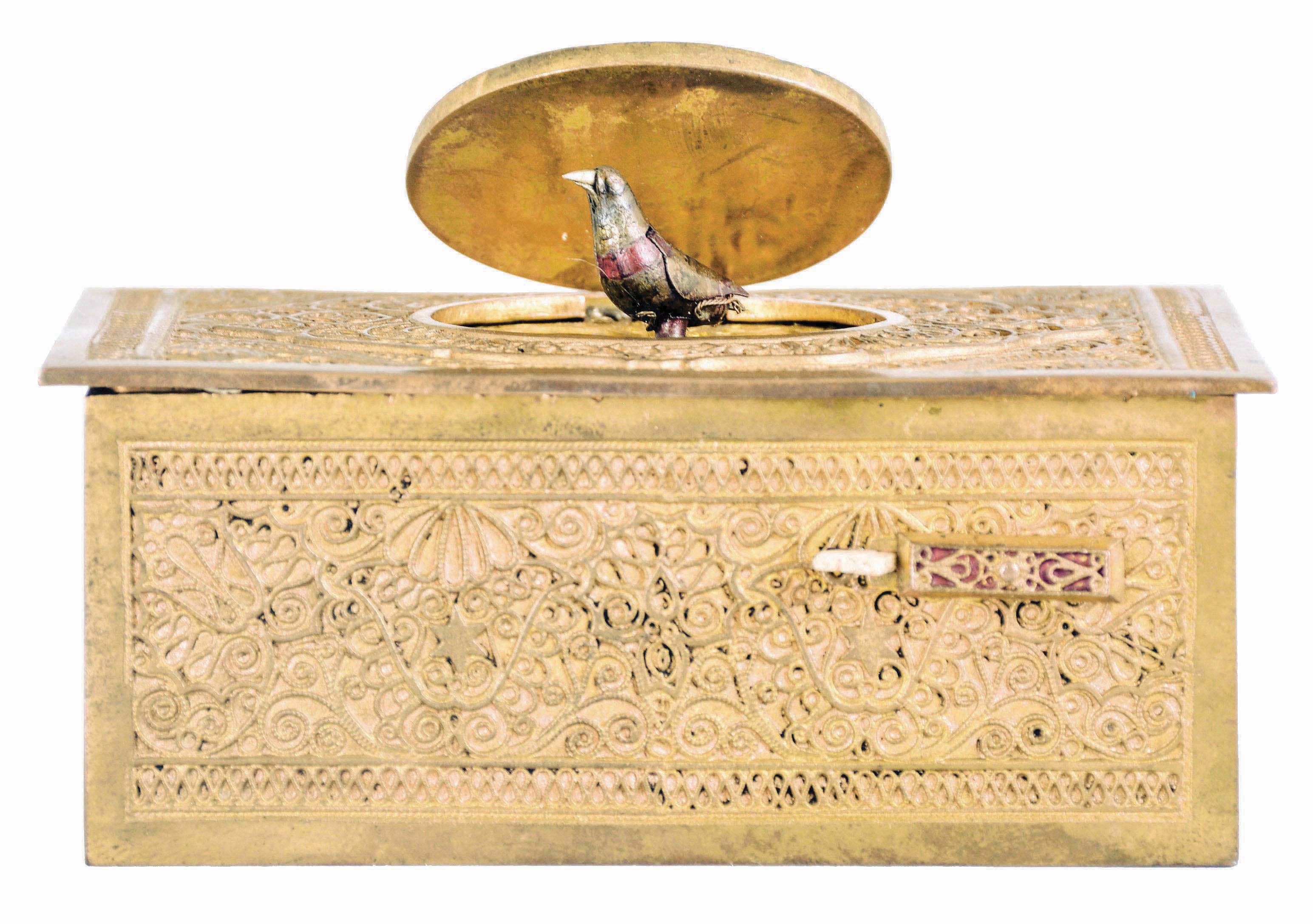 Germany, probably Karl Griesbaum, singing bird box, gilt brass case with ornate filigree applique, the front with slide for activating the bird, appearing from beneath the oval cover and performing on demand, 20th century — Antique Clocks Price Guide