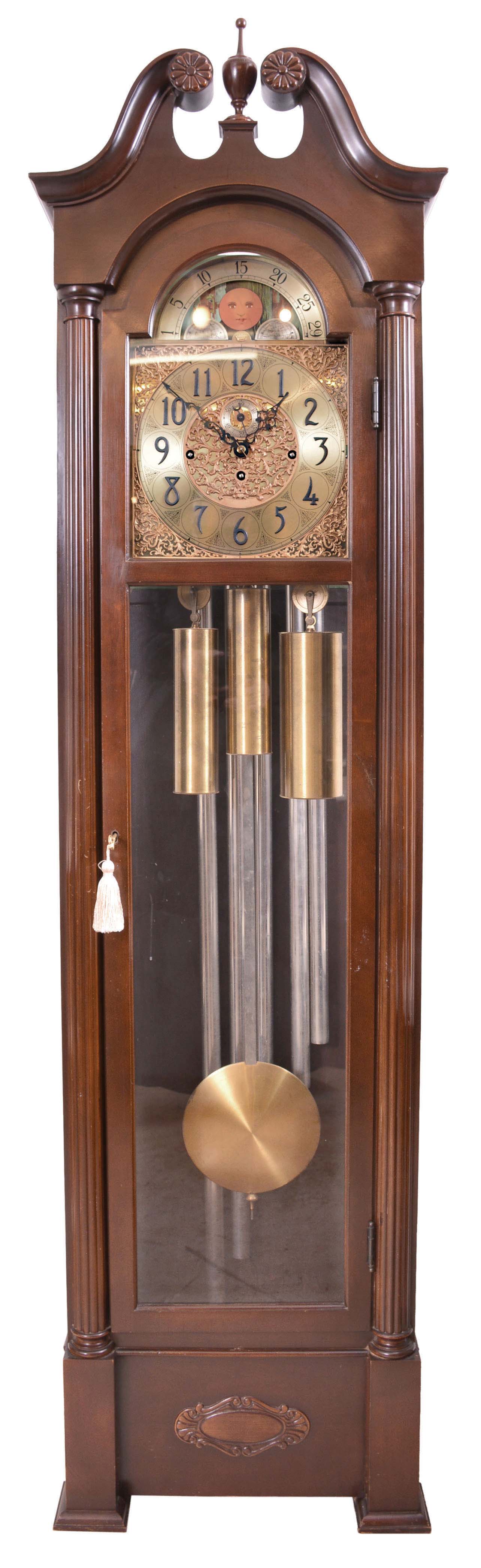 Herschede Clock Co., Cincinnati, OH, 8 day, three-train, chiming, weight-driven movement playing Westminster on five tubes in a mahogany case flanked with fluted half-columns and broken pediment with center finial. Brass dial with silvered chapter ring, strike / silent selector, applied cast brass and engraved dial center and spandrels and moon phase, serial number 437470. — Antique Clocks Price Guide