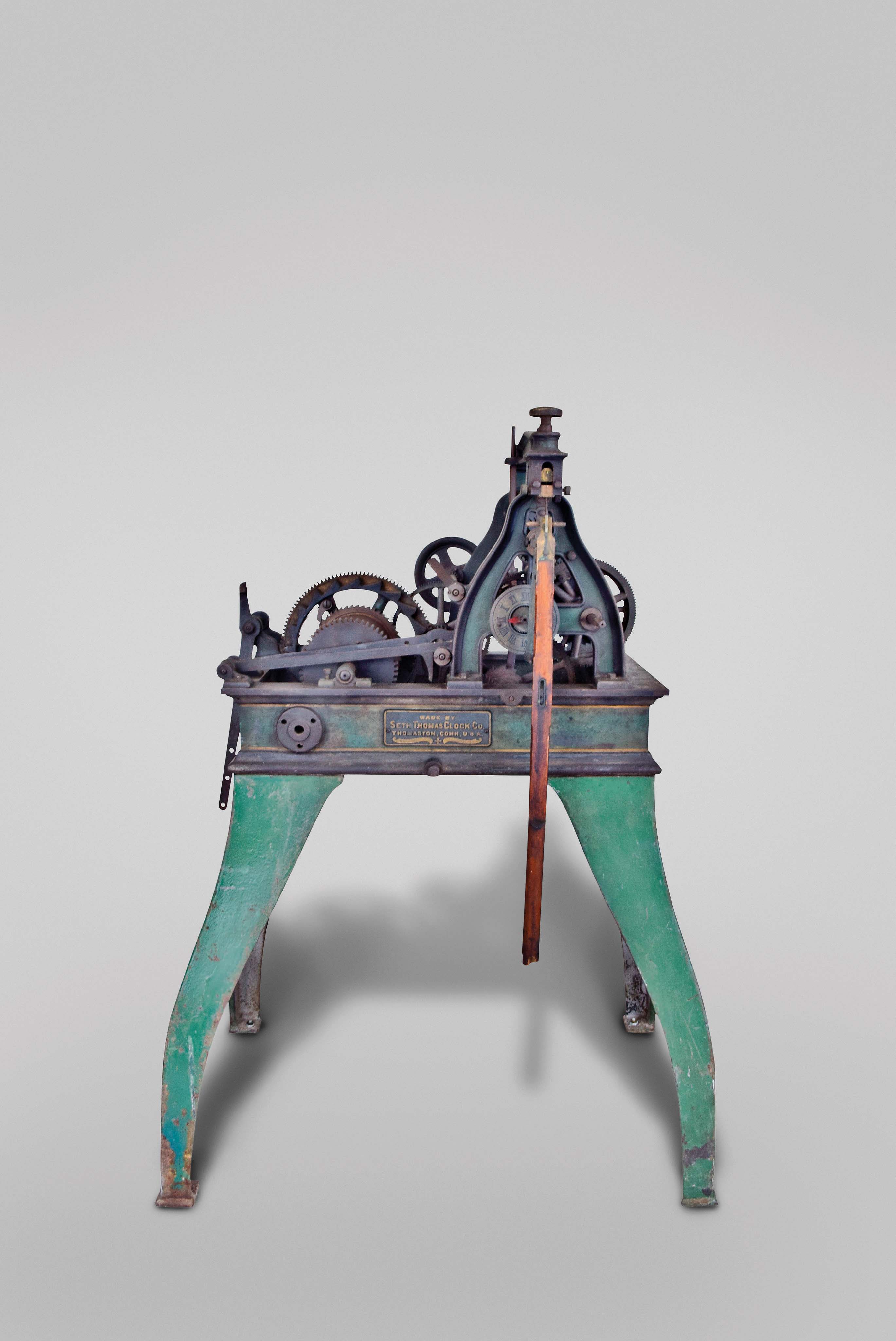 Seth Thomas Clock Co., Thomaston Conn., "No. 15 Hour Strike Tower Clock", time and strike, weight driven movement with Graham deadbeat escapement in green, black and gold painted cast iron frame, serial #1343, dated March 19, 1906 including including 4-way differential, motion works, one wooden 30in dial and hour hand, hand forged weight hooks, pulleys, transmission, distribution linkage, 10" weights and crank — Antique Clocks Price Guide