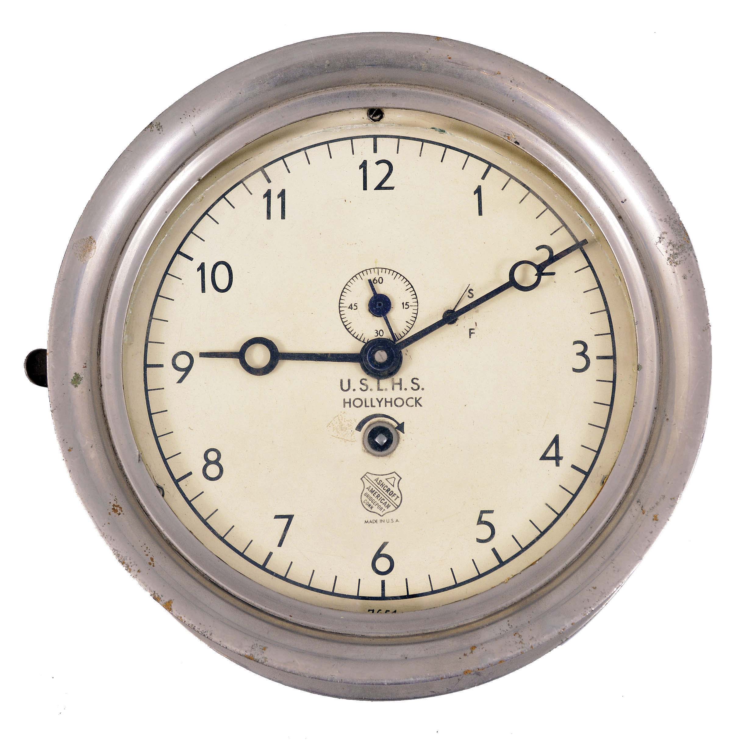 Chelsea Clock Co., Boston, Mass., for Ashcroft American, Bridgeport, Conn., for U.S. Lighthouse Service, deck clock, 8 day, time only, spring-driven jeweled balance wheel movement in a nickel plated case with hinged bezel, 6.5 inch white painted dial reading "U.S.L.H.S., Hollyhock" indicating that it was once installed aboard the U.S. Lighthouse Service tender "Hollyhock", movement serial number 99703 — Antique Clocks Price Guide