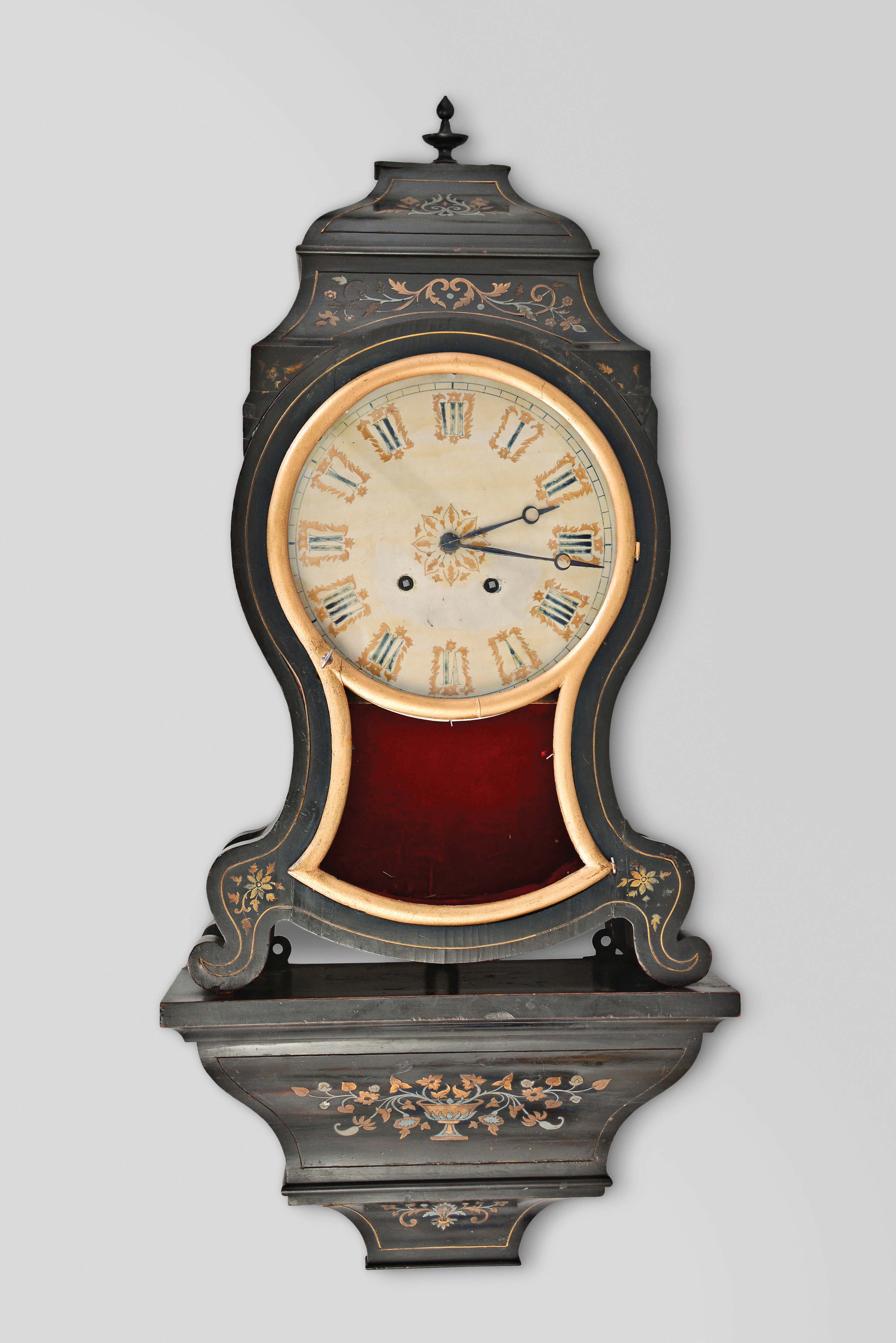 Switzerland, an inlaid, ebonized "Pendule Neuchateloise" style clock with matching bracket, the case with painted flowers, brass line inlay, and foliate designs of pewter and brass which are carried through to the bracket, case door with pierced, fabric backed fret below bezel glass, roman numeral white painted dial with gold painted embellishments, blued steel Breguet style hands, 8 day, two train movement with square plates, silk thread suspension, and striking on a gong attached to the case back — Antique Clocks Price Guide