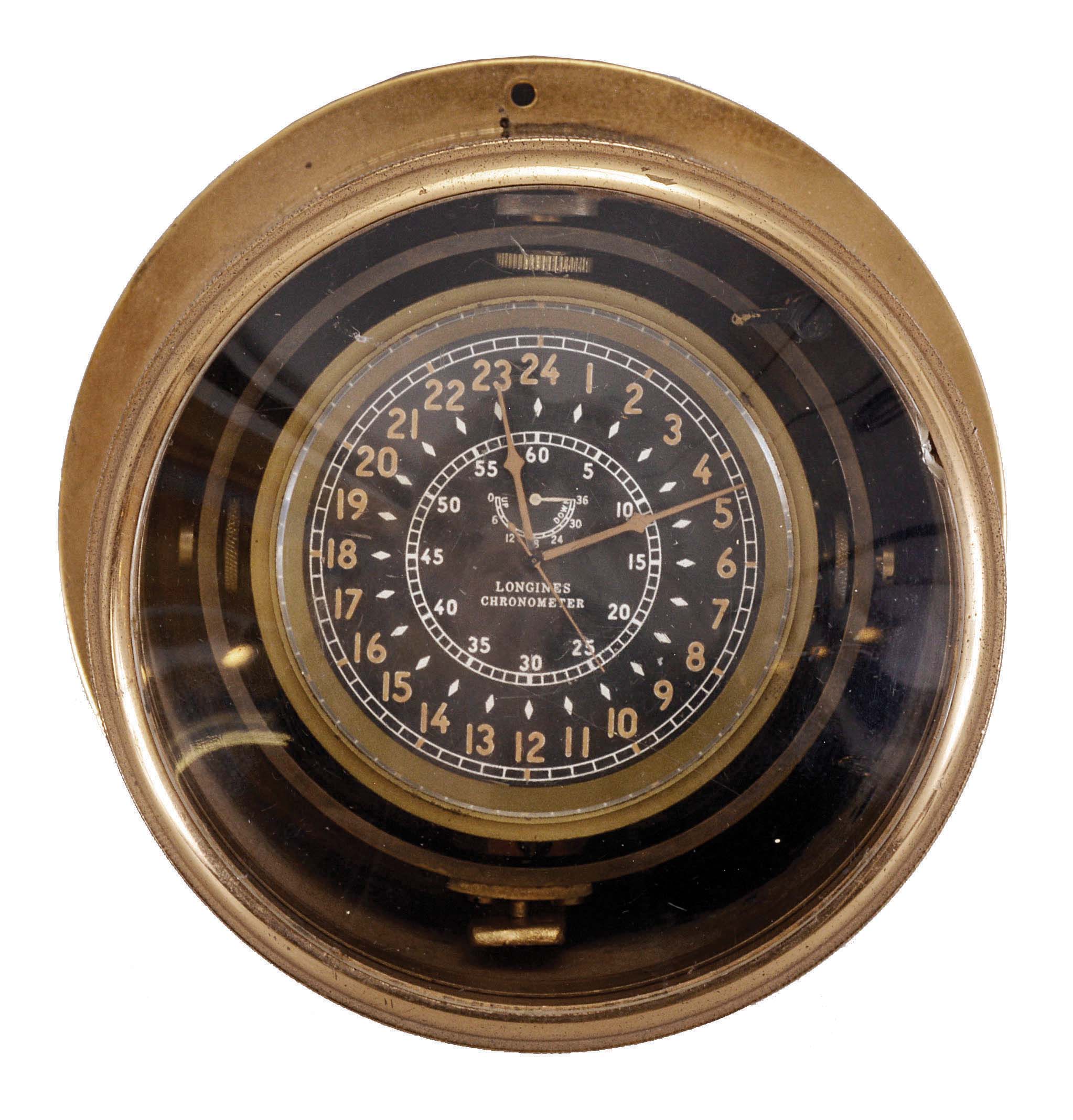 Longines, Switzerland, a bronze cased, one day lever chronometer with center seconds and wind indicator, 21 jewels, stem wind and set, adjusted to 5 positions and temperature, cotes de Geneve decorated nickel plate movement with lever escapement, monometallic balance and Wilmot micrometric regulator in a weighted, gimbal mounted brass case, with Arabic numeral, black painted 24 hour dial and luminous hands, all contained in a purpose made cylindrical bronze case with screw bezel and mounting flange — Antique Clocks Price Guide